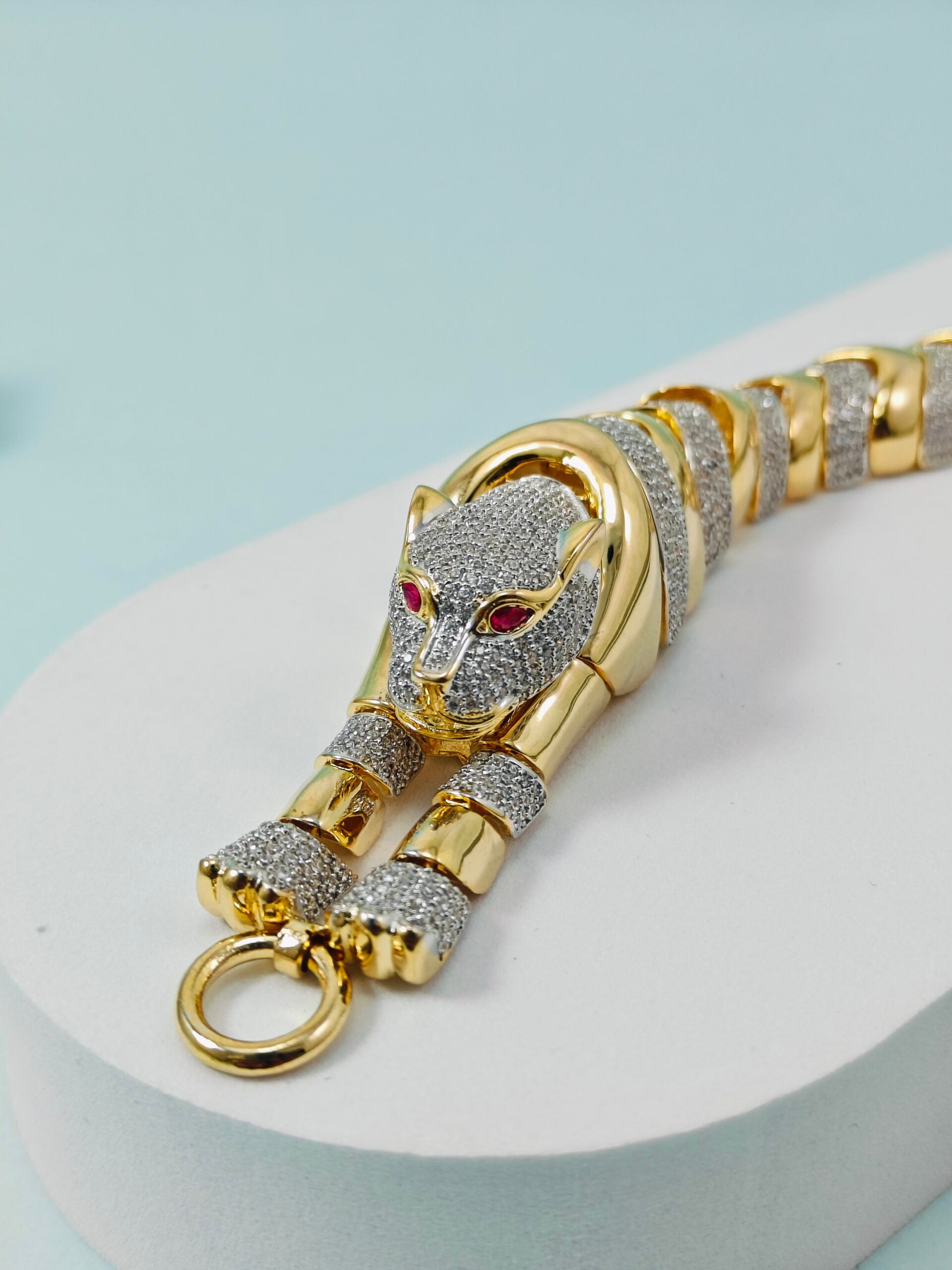 Gold and silver panther bracelet on a light blue background