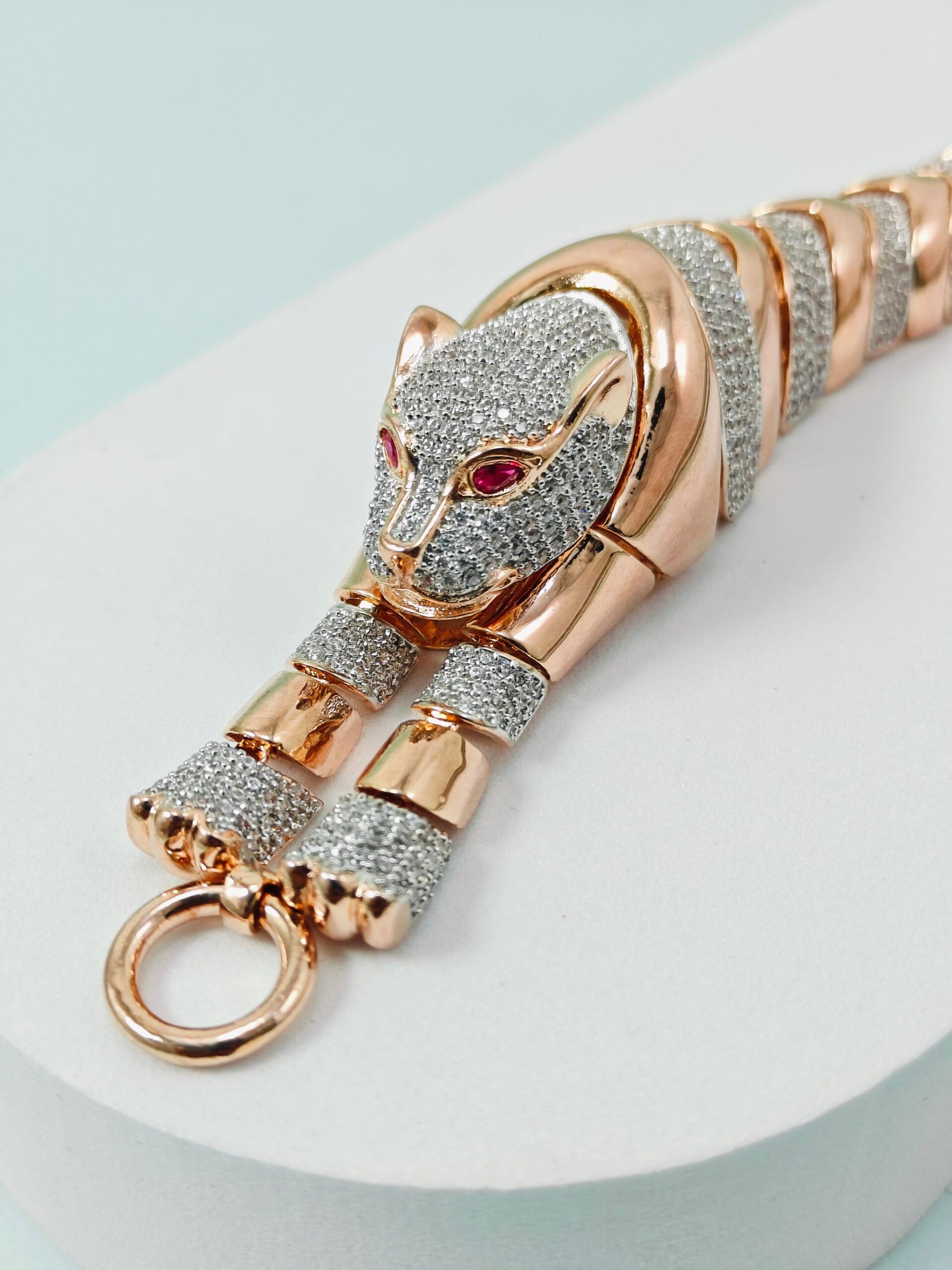 Gold and silver panther keychain on a light blue background