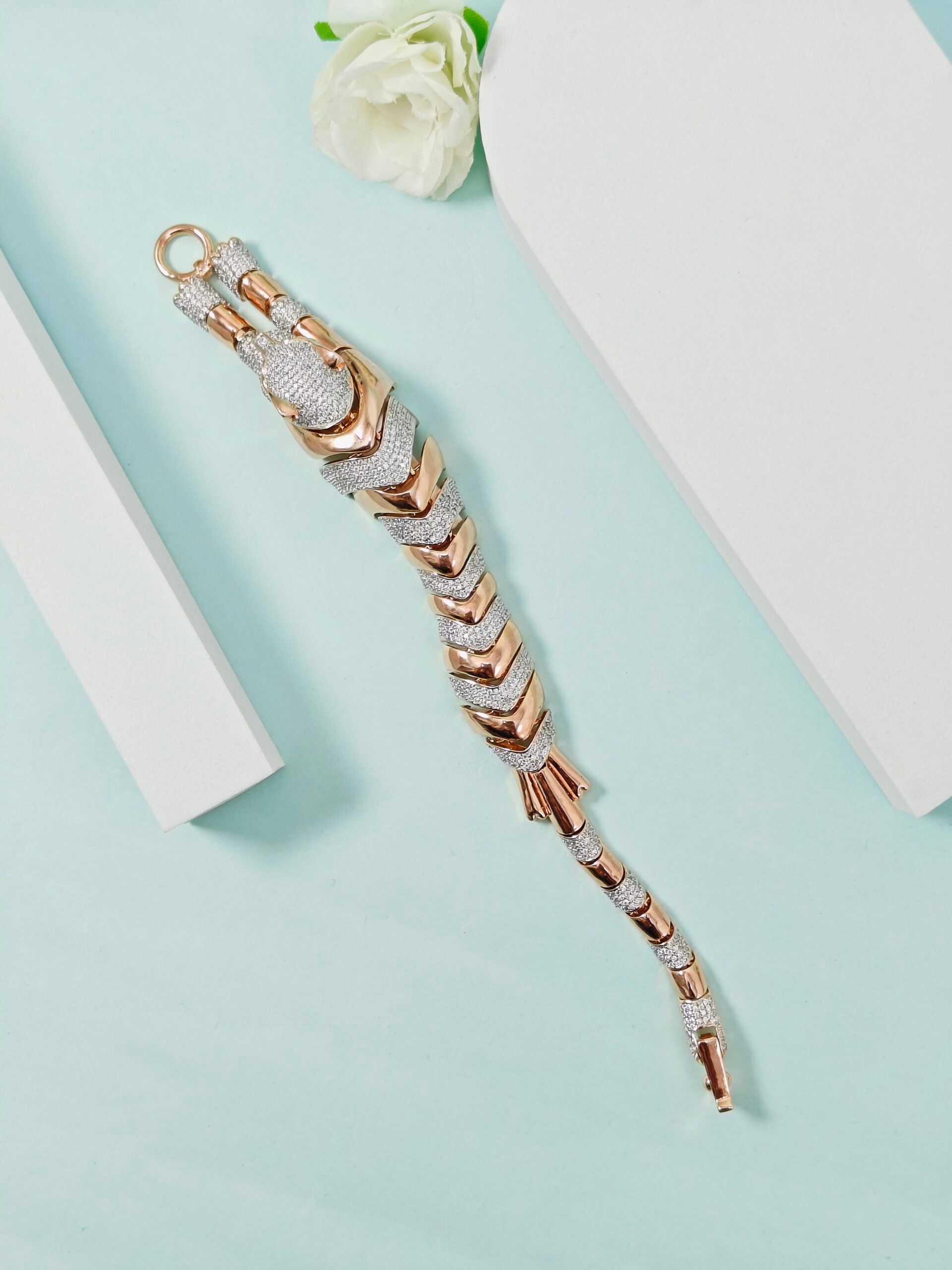 Decorative keychain with gold and silver accents on a light blue background