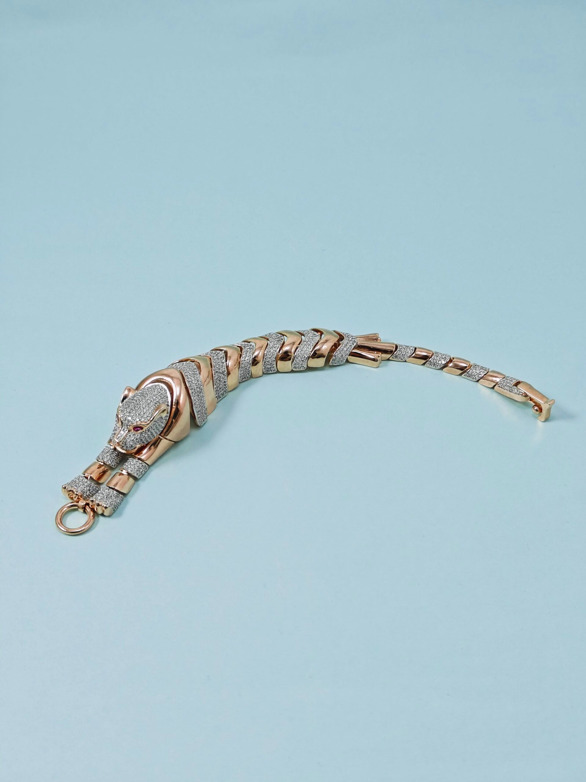 Gold and silver bracelet on a light blue background