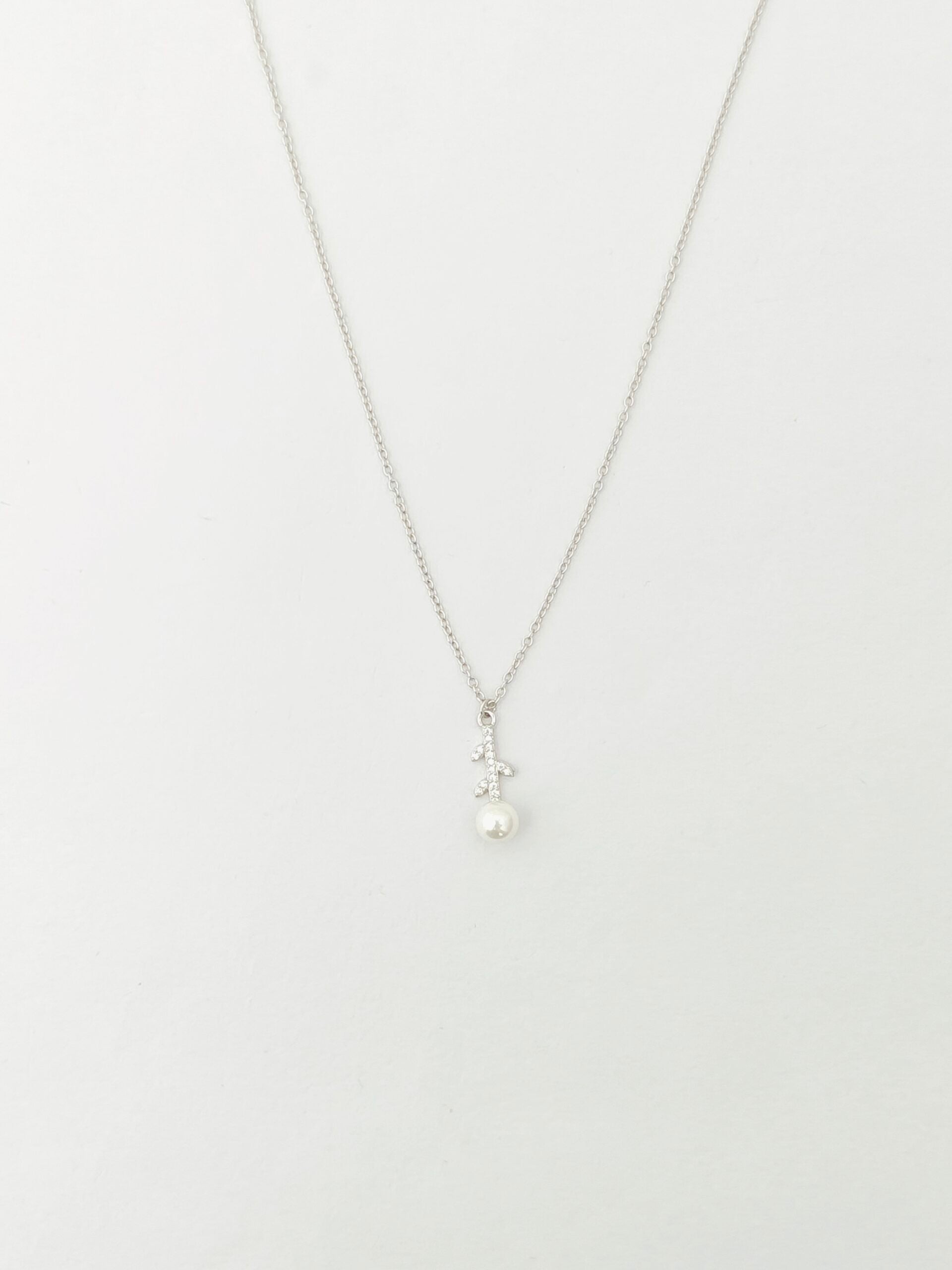 Pearl necklace on a thin chain against a white background