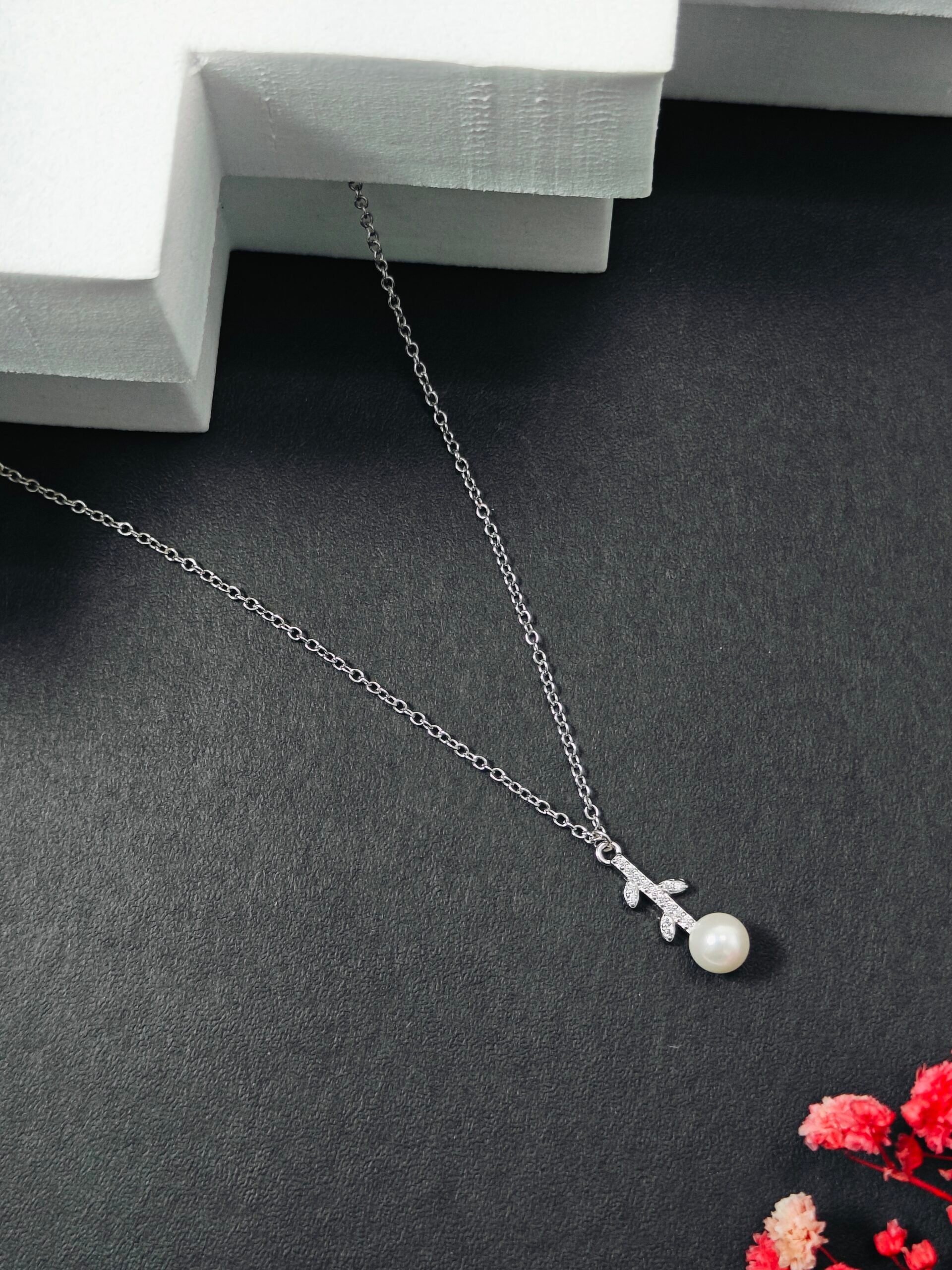 Necklace with a pearl pendant on a dark surface