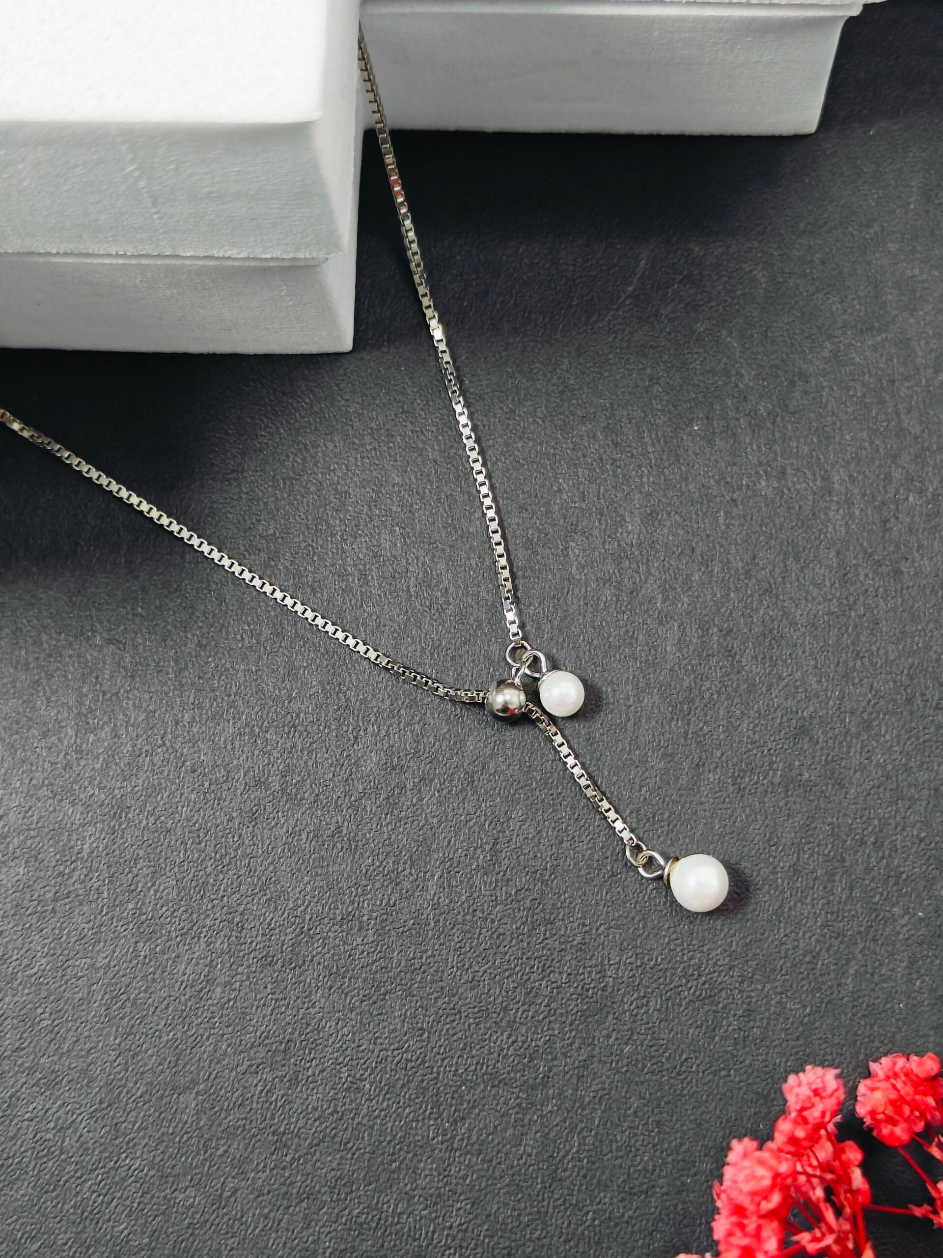 Necklace with small round pendants on a dark surface