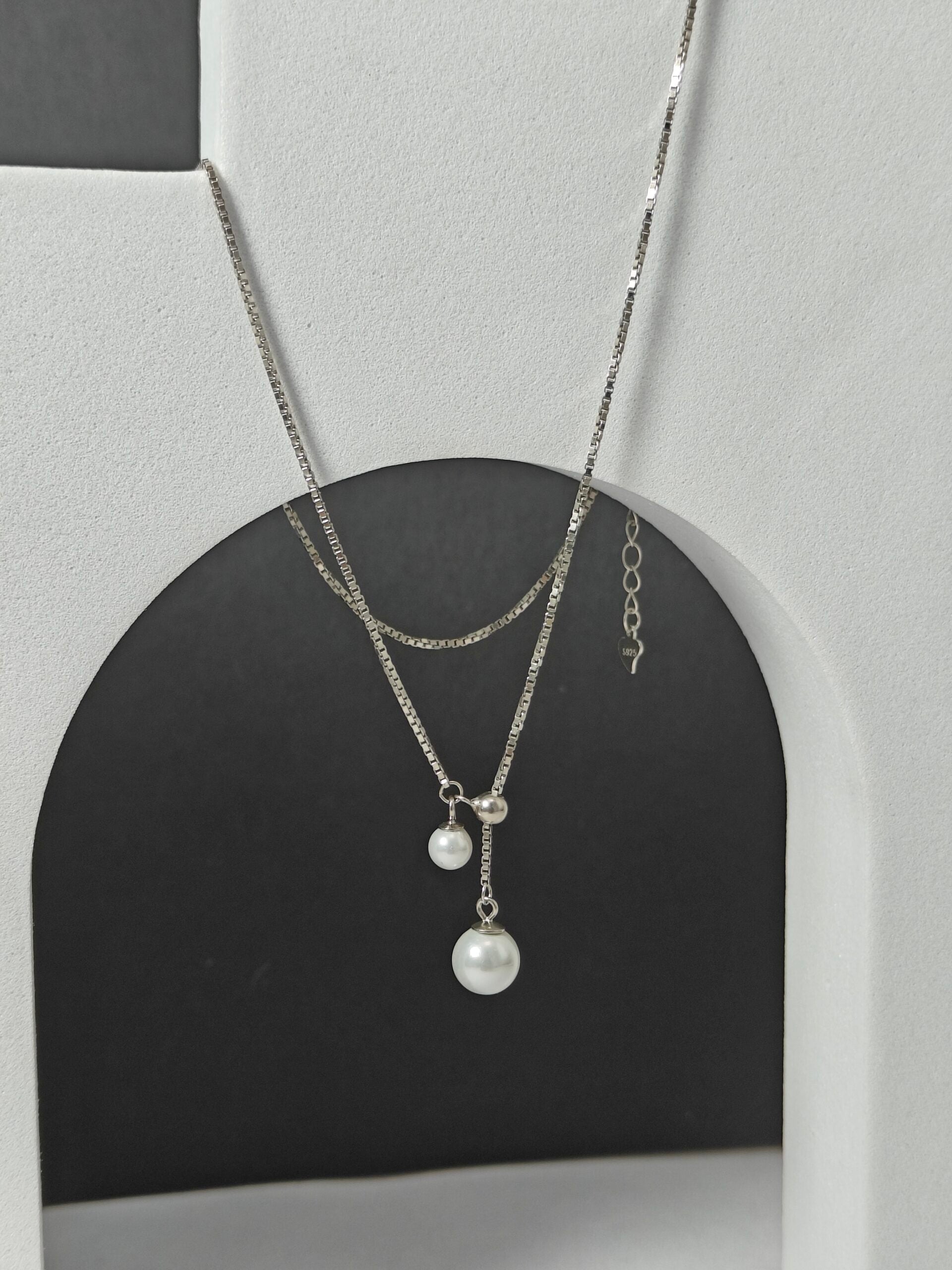 Necklace with pearl pendants on a gray and black background