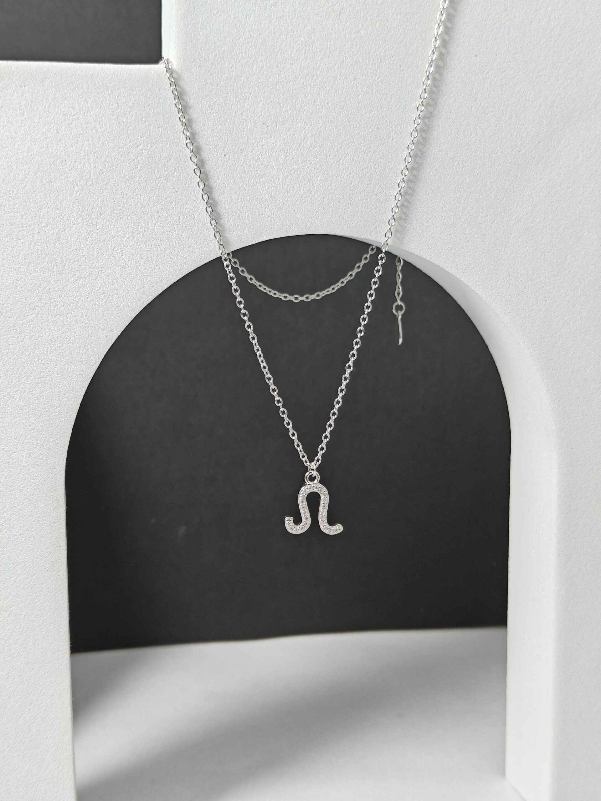 Silver necklace with a unique pendant on a black and white background