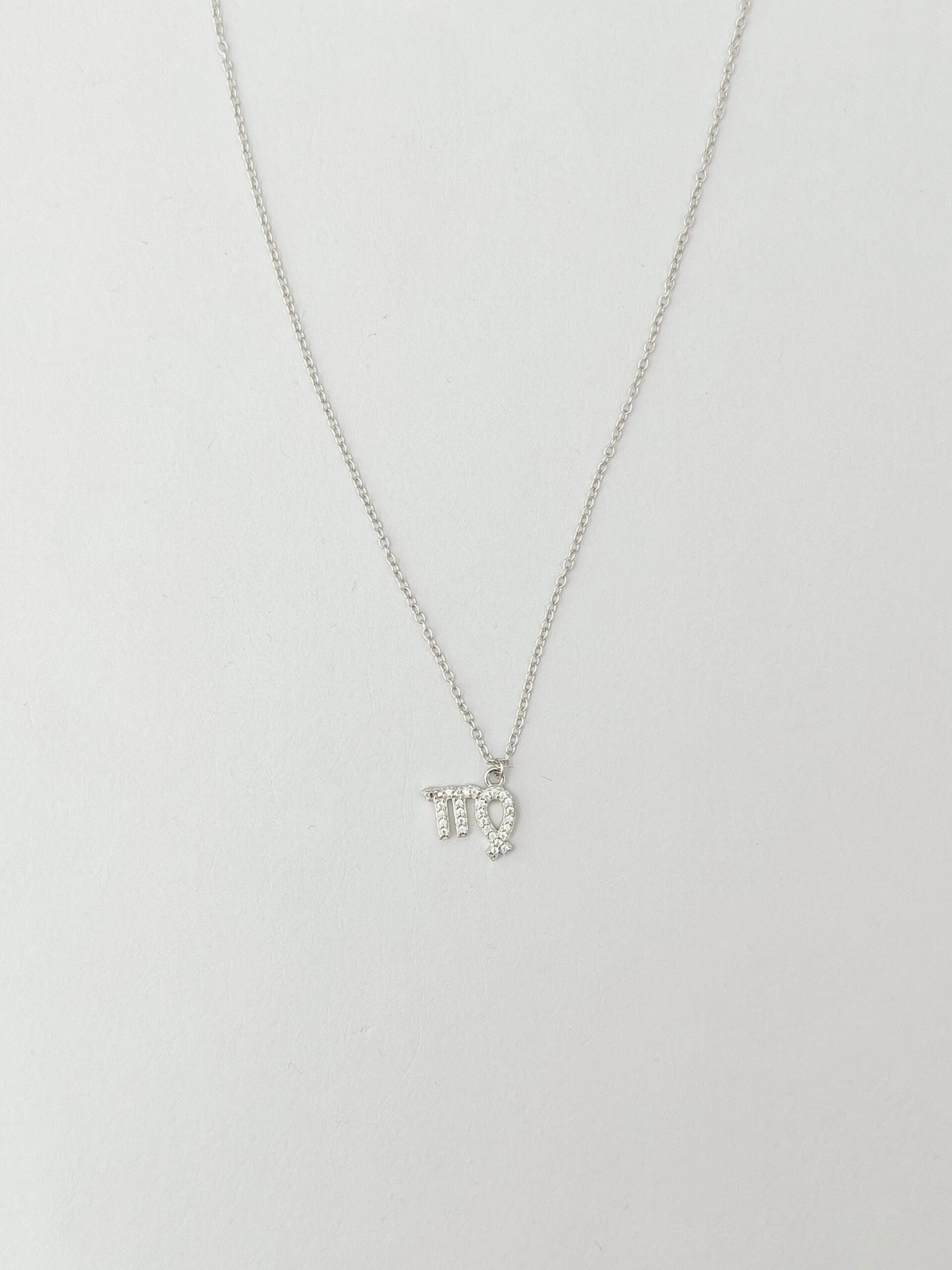 Silver necklace with a small pendant on a light gray background