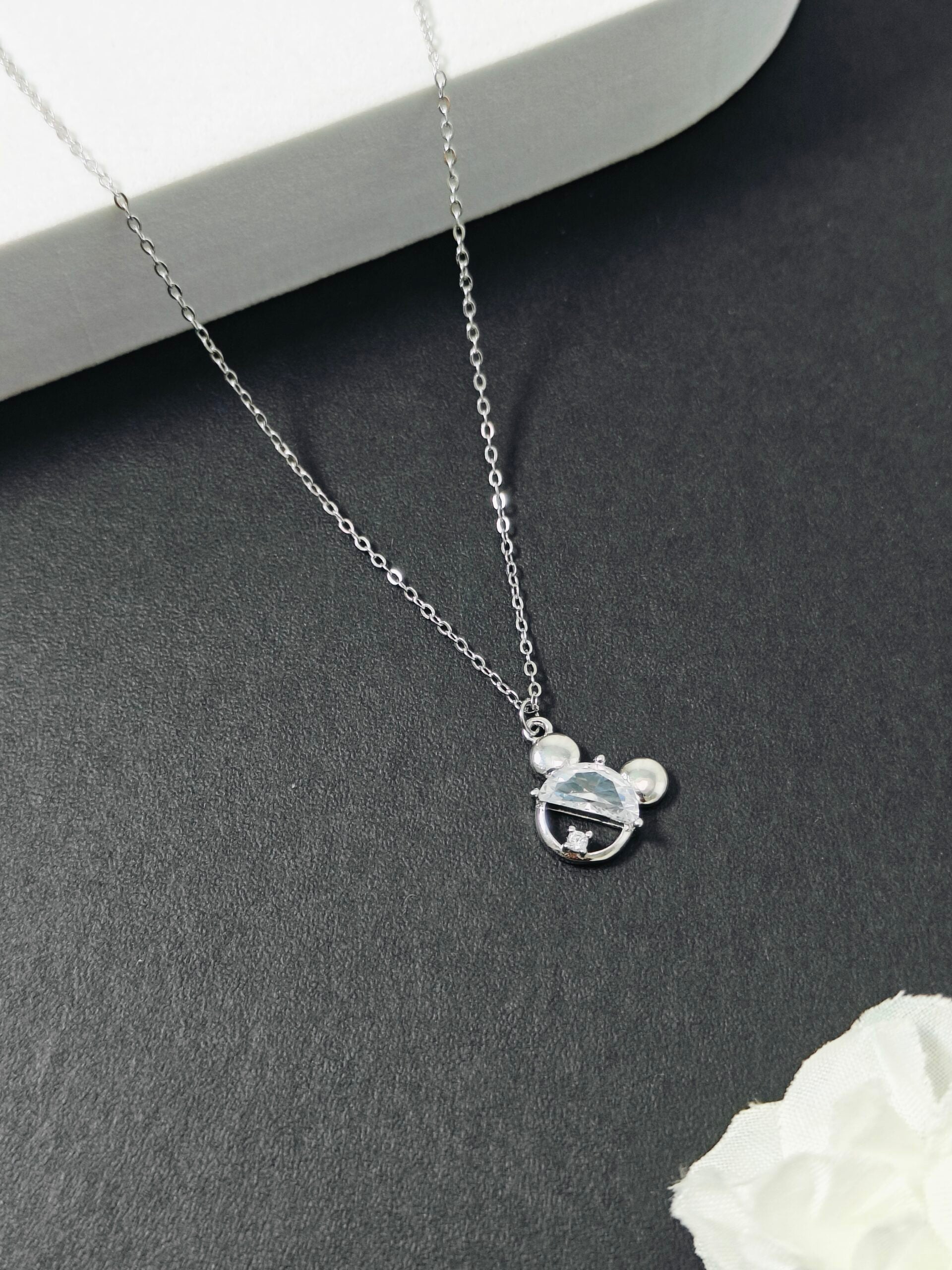 Silver necklace with a pendant on a dark surface