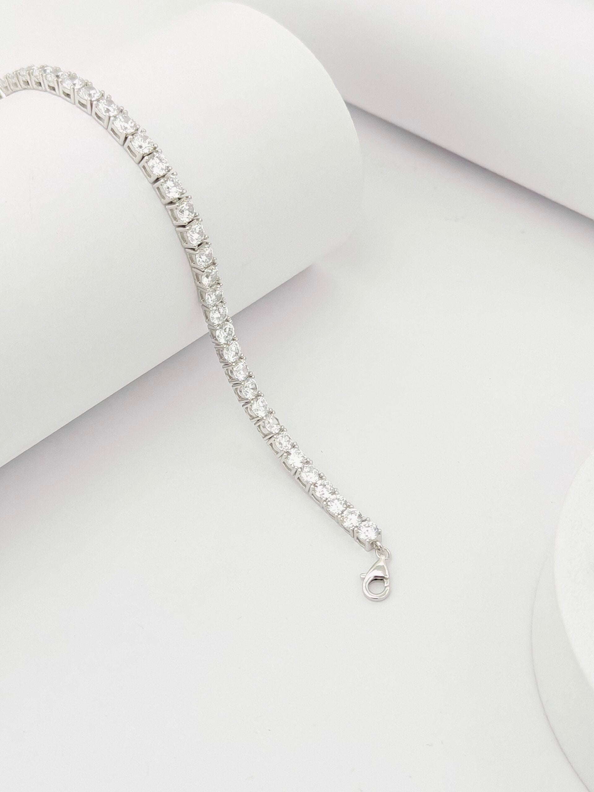 Silver bracelet with clear stones on a light gray background