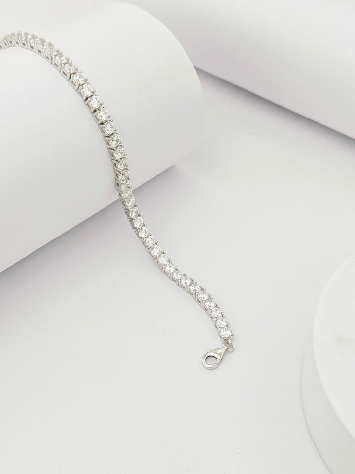 Silver bracelet with clear stones on a light gray background