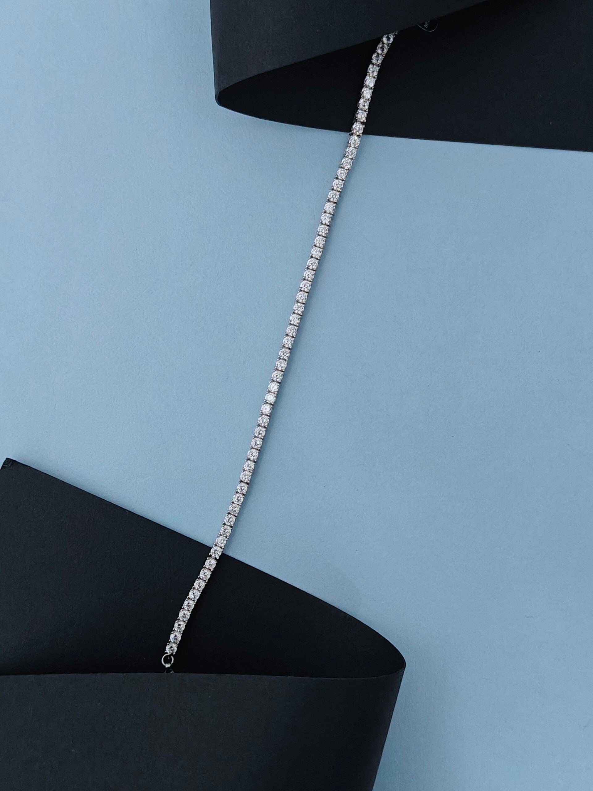 Silver chain necklace on a black and blue background