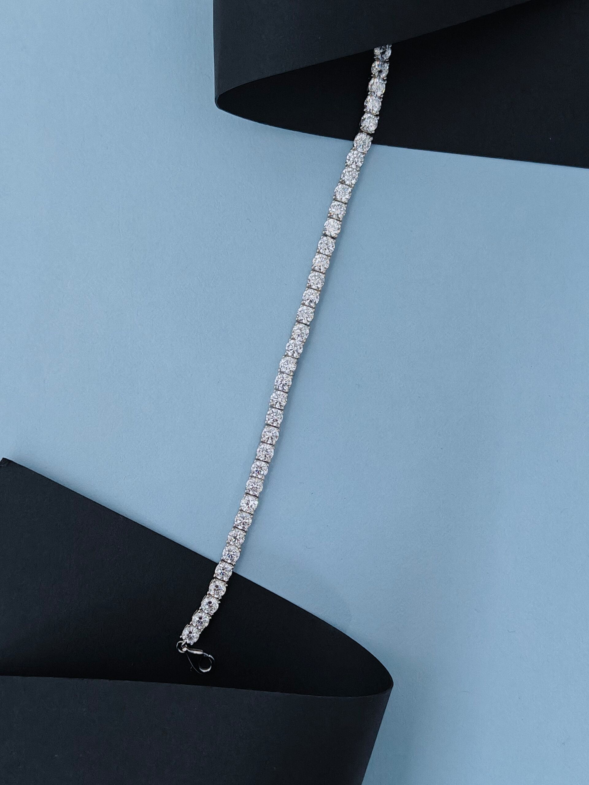 Silver bracelet on a black and light blue background