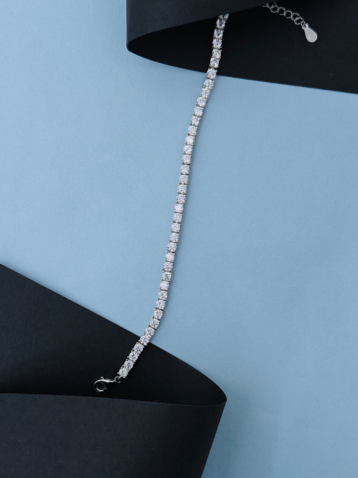 Silver bracelet with clear stones on a black and blue background