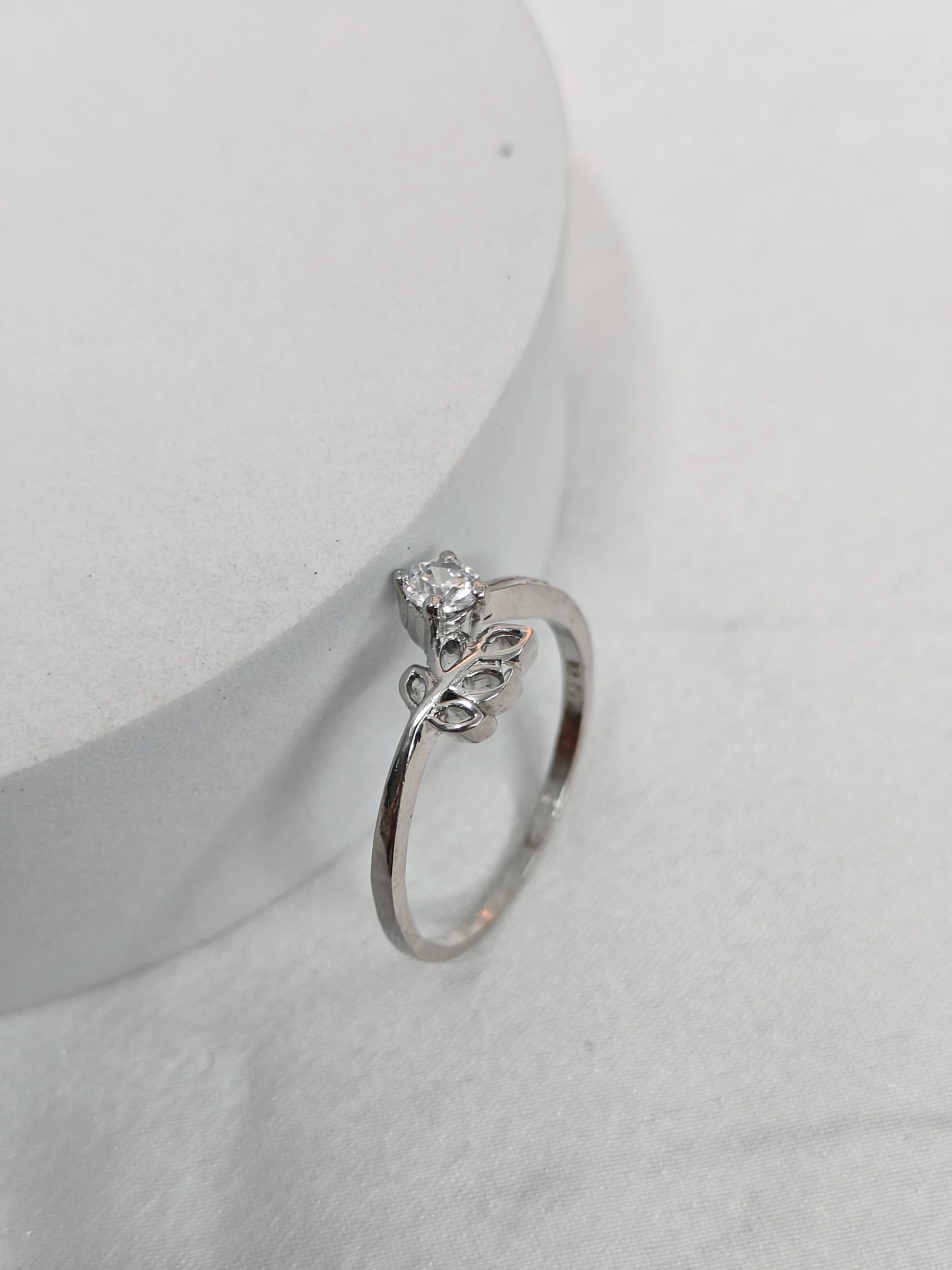 Silver ring with a diamond on a white background