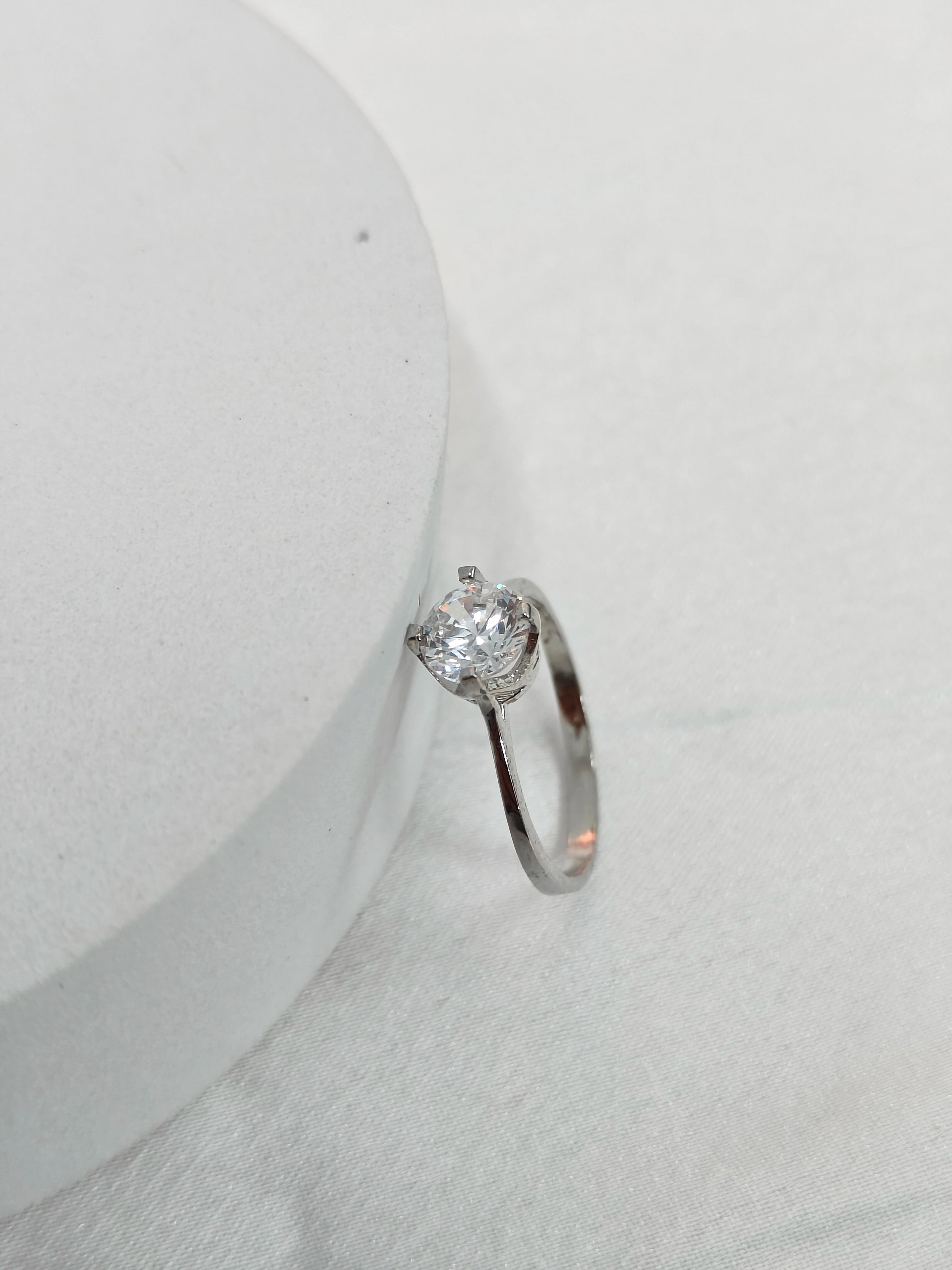 Silver ring with a diamond on a white background