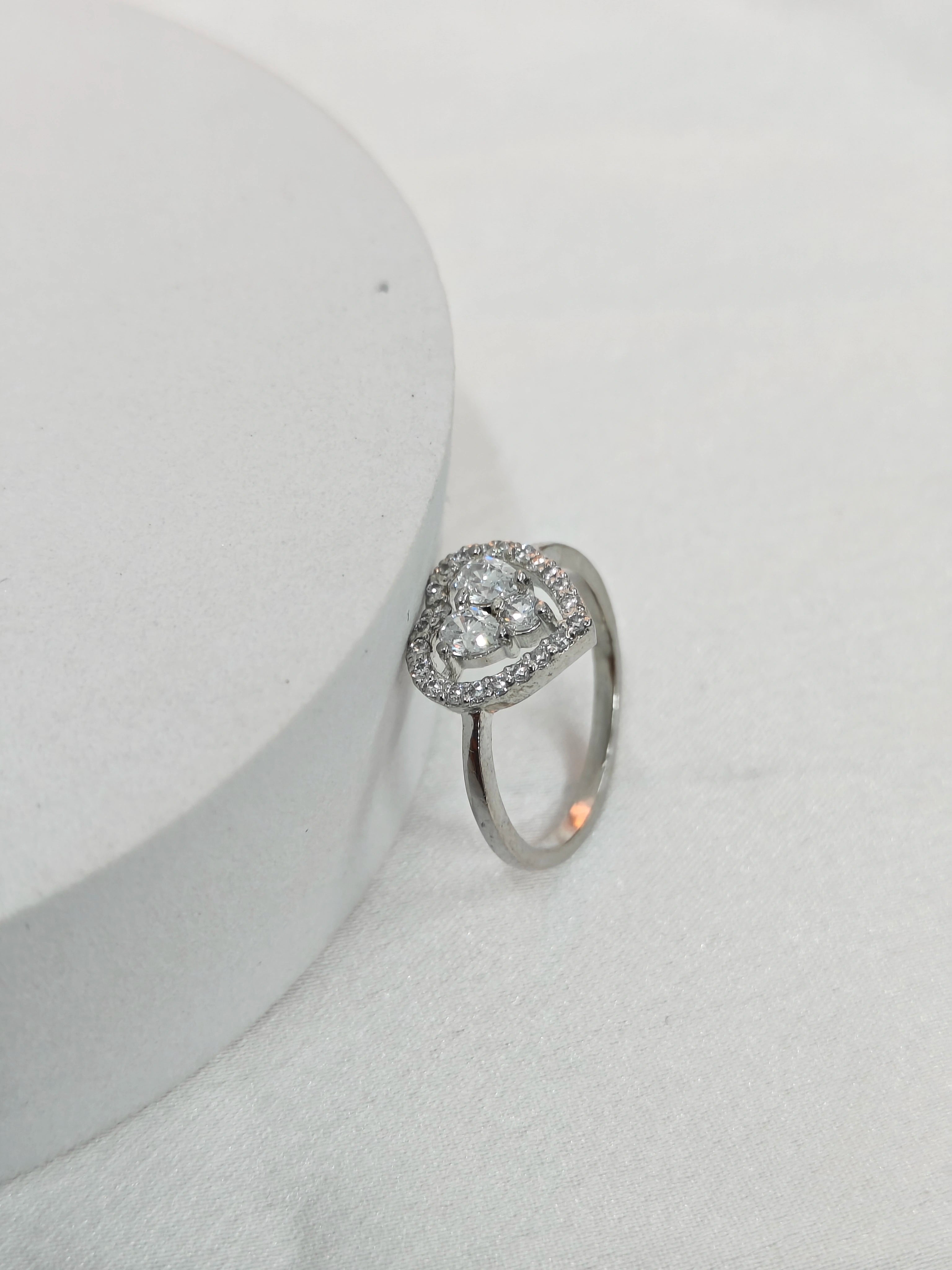 Silver ring with a diamond on a light gray background
