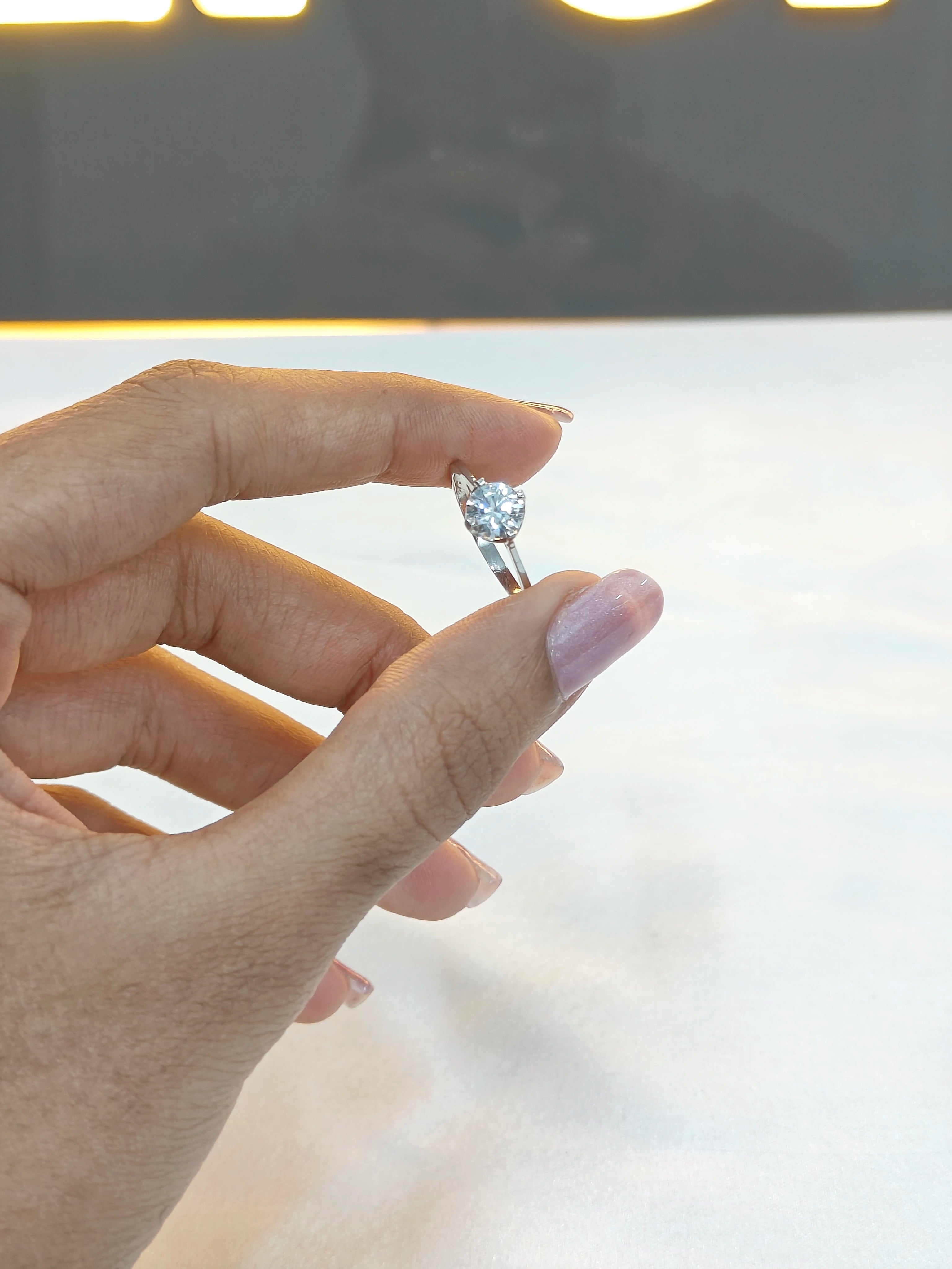 Hand holding a diamond ring with a blurred background