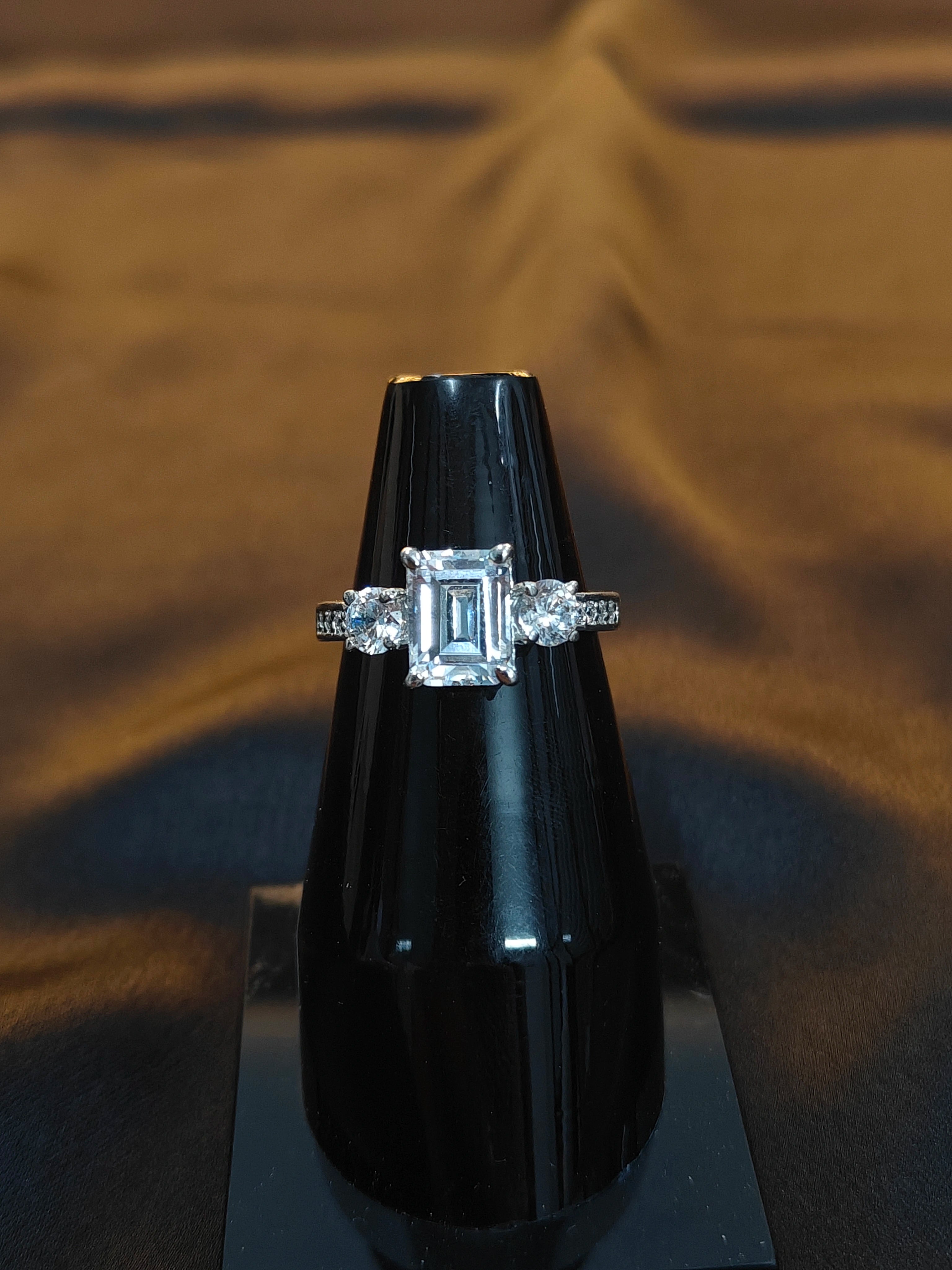 Diamond ring on a black stand against a brown fabric background