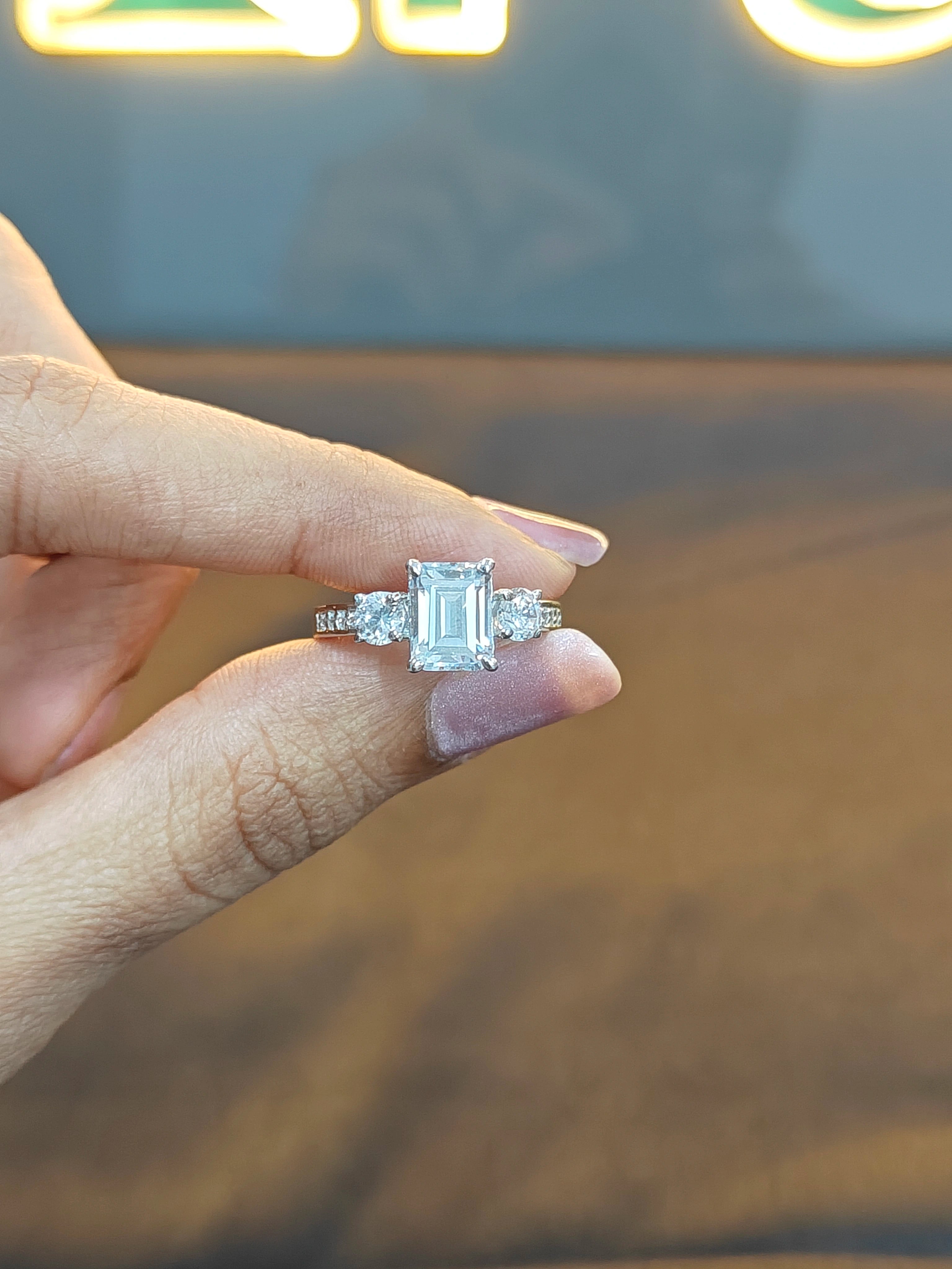 Diamond ring held between fingers with a blurred background