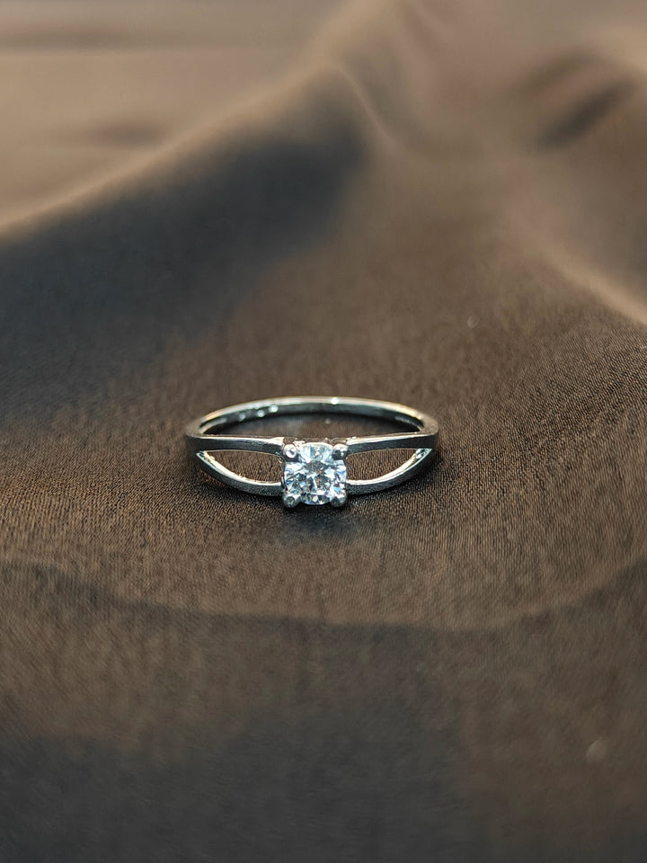 Silver ring with a diamond on a brown fabric background