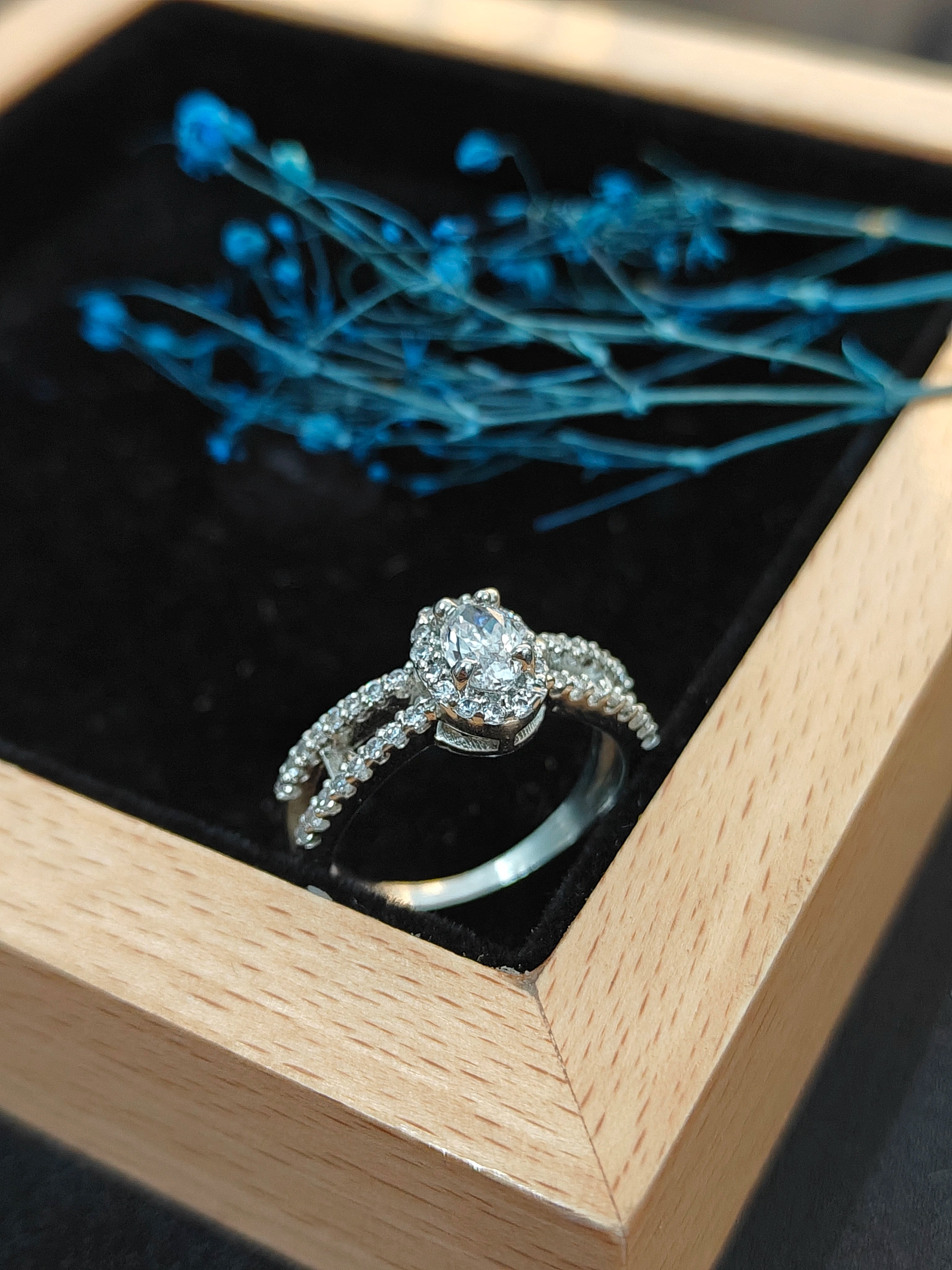 Diamond ring in a wooden box with blue flowers