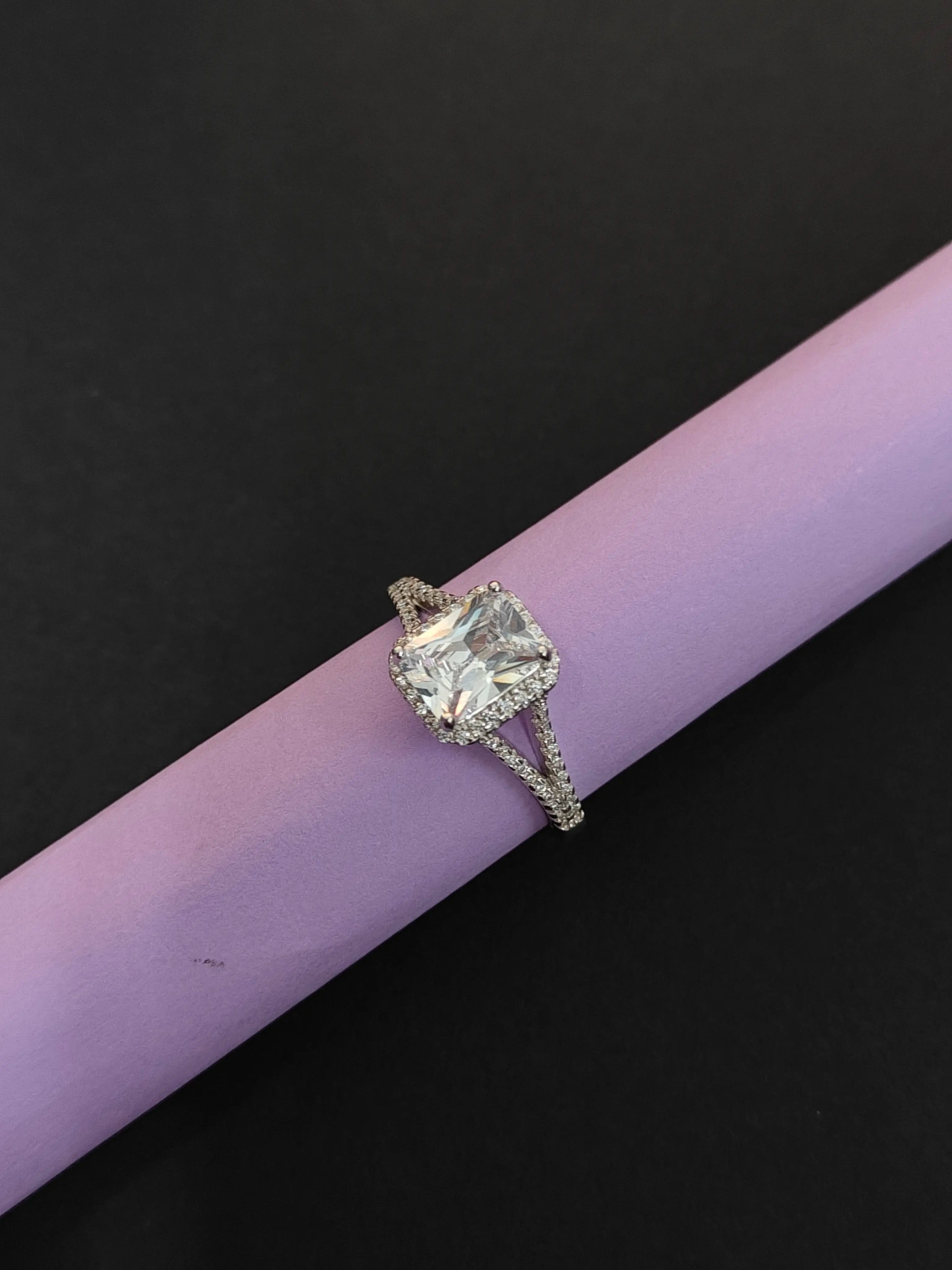 Diamond ring on a purple cylindrical object with a black background