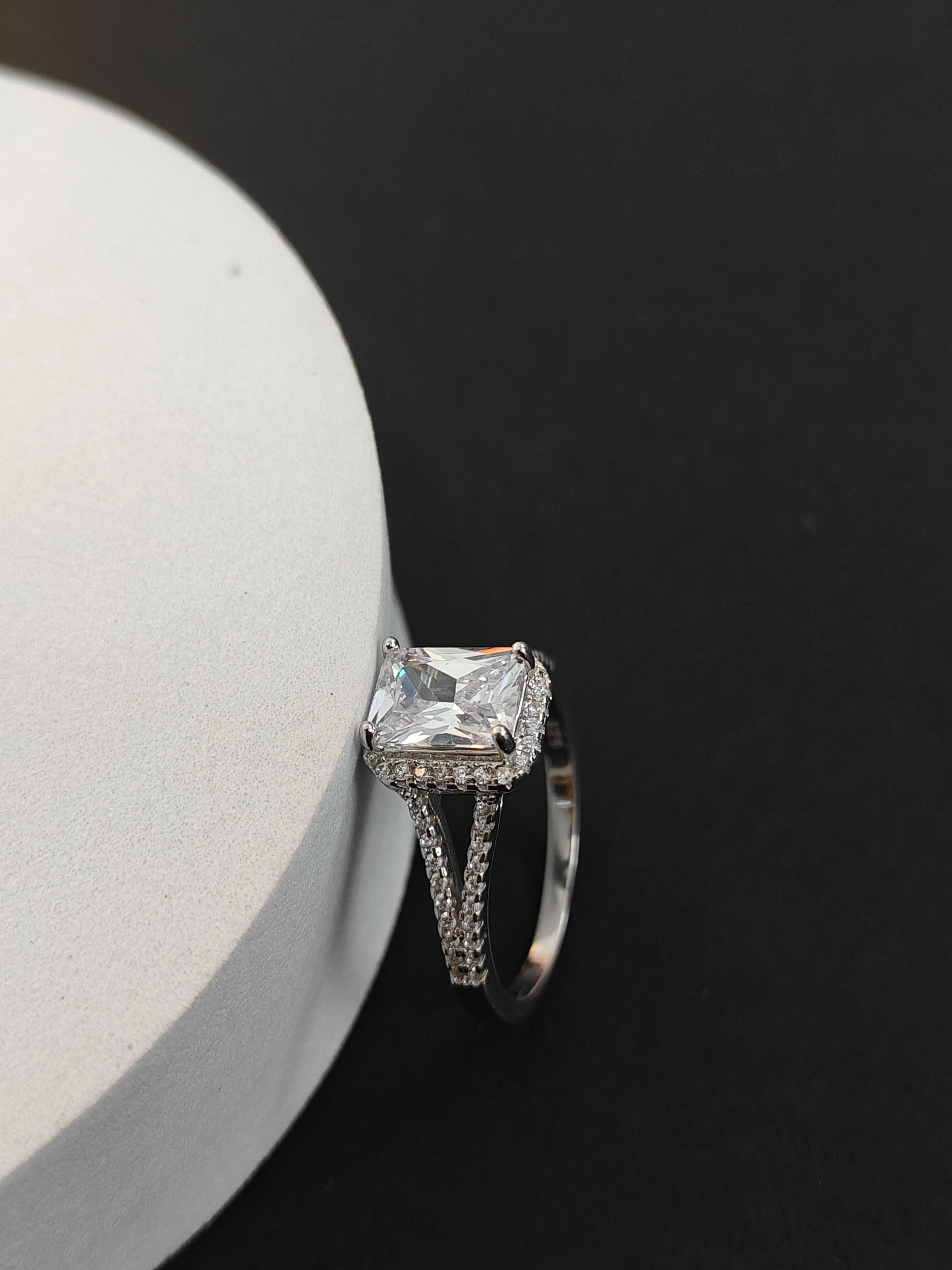 Silver ring with a large diamond on a black background