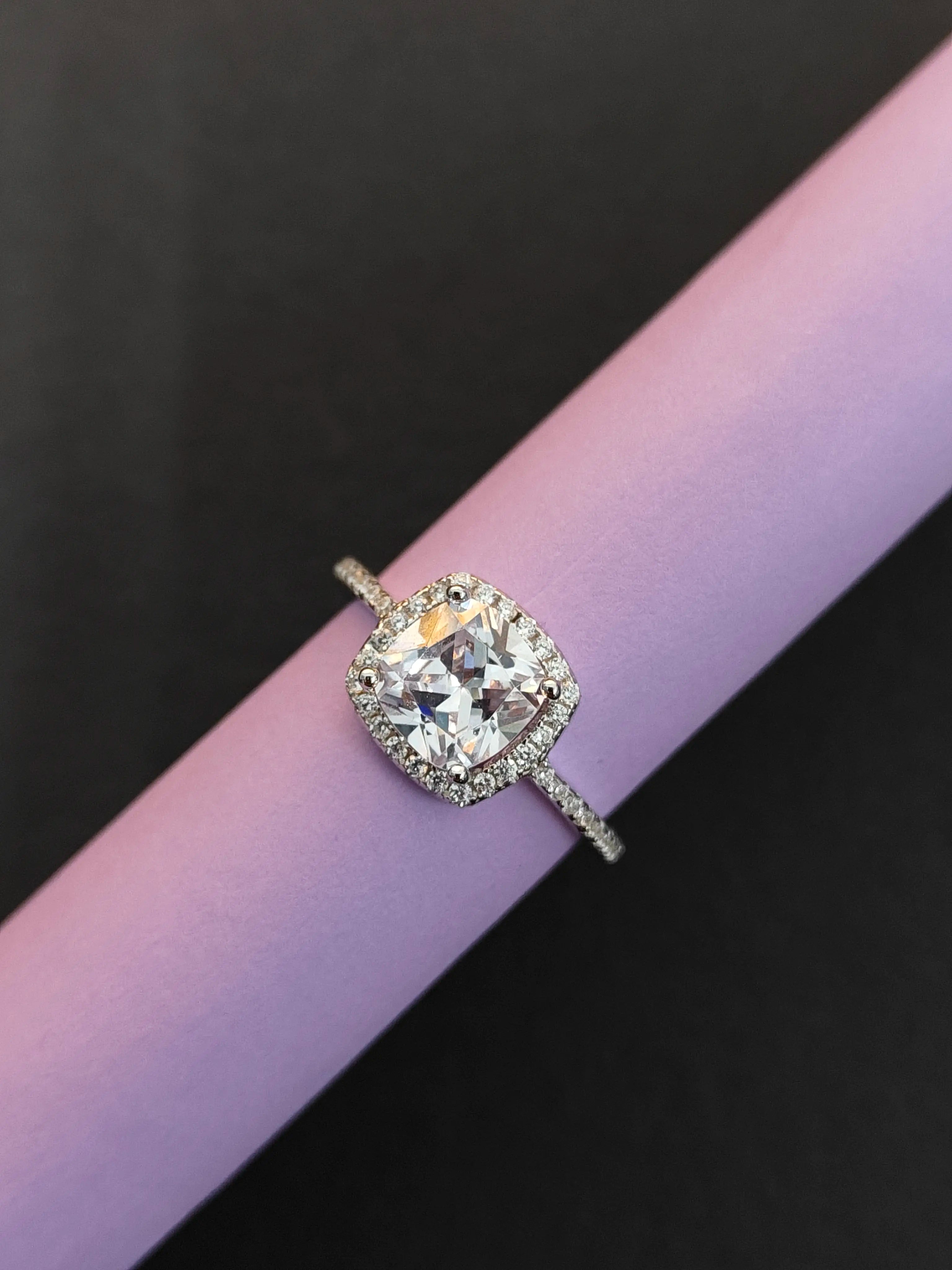 Diamond ring on a pink and black background