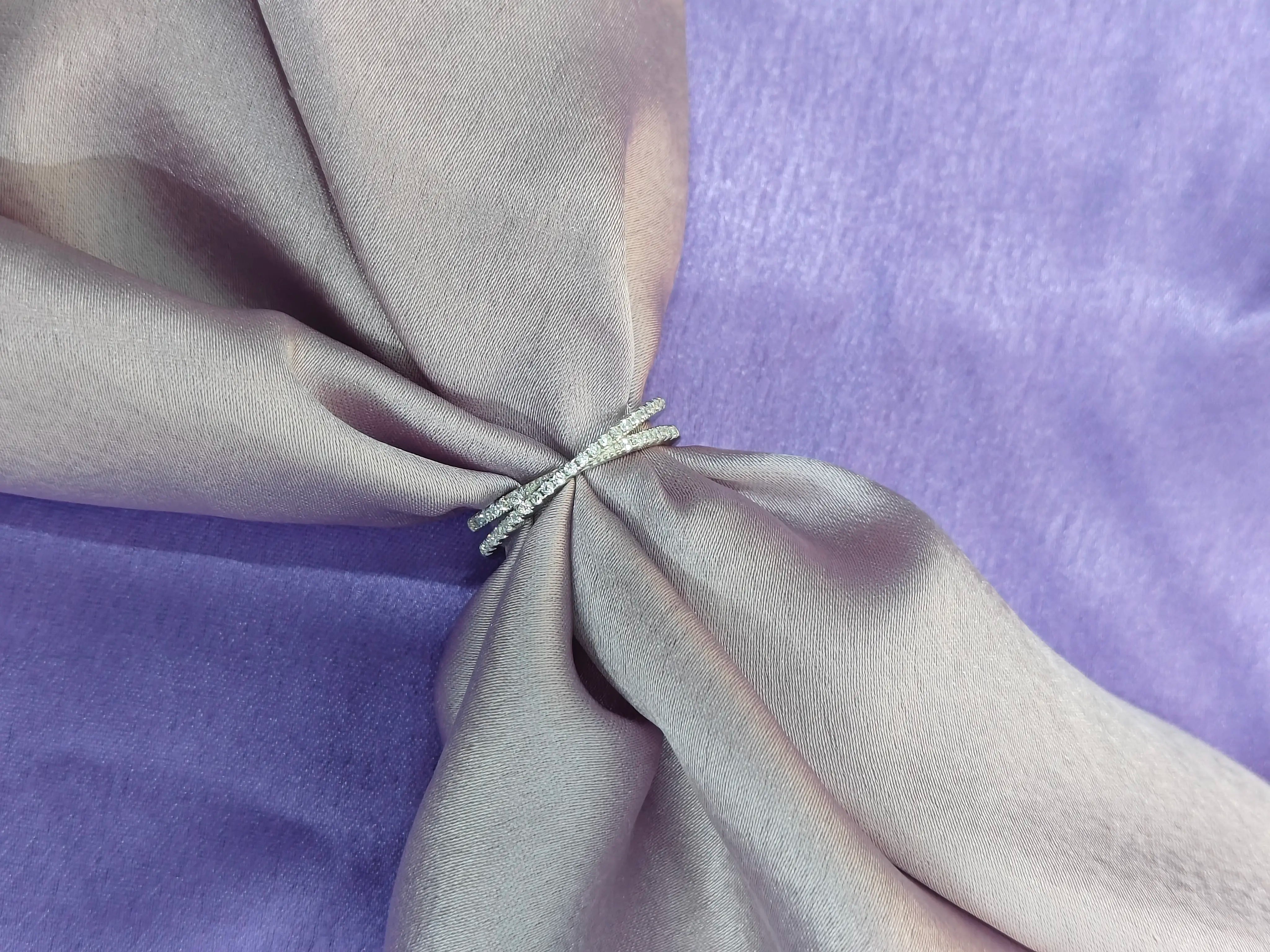 Silver ring on a folded gray fabric with a purple background
