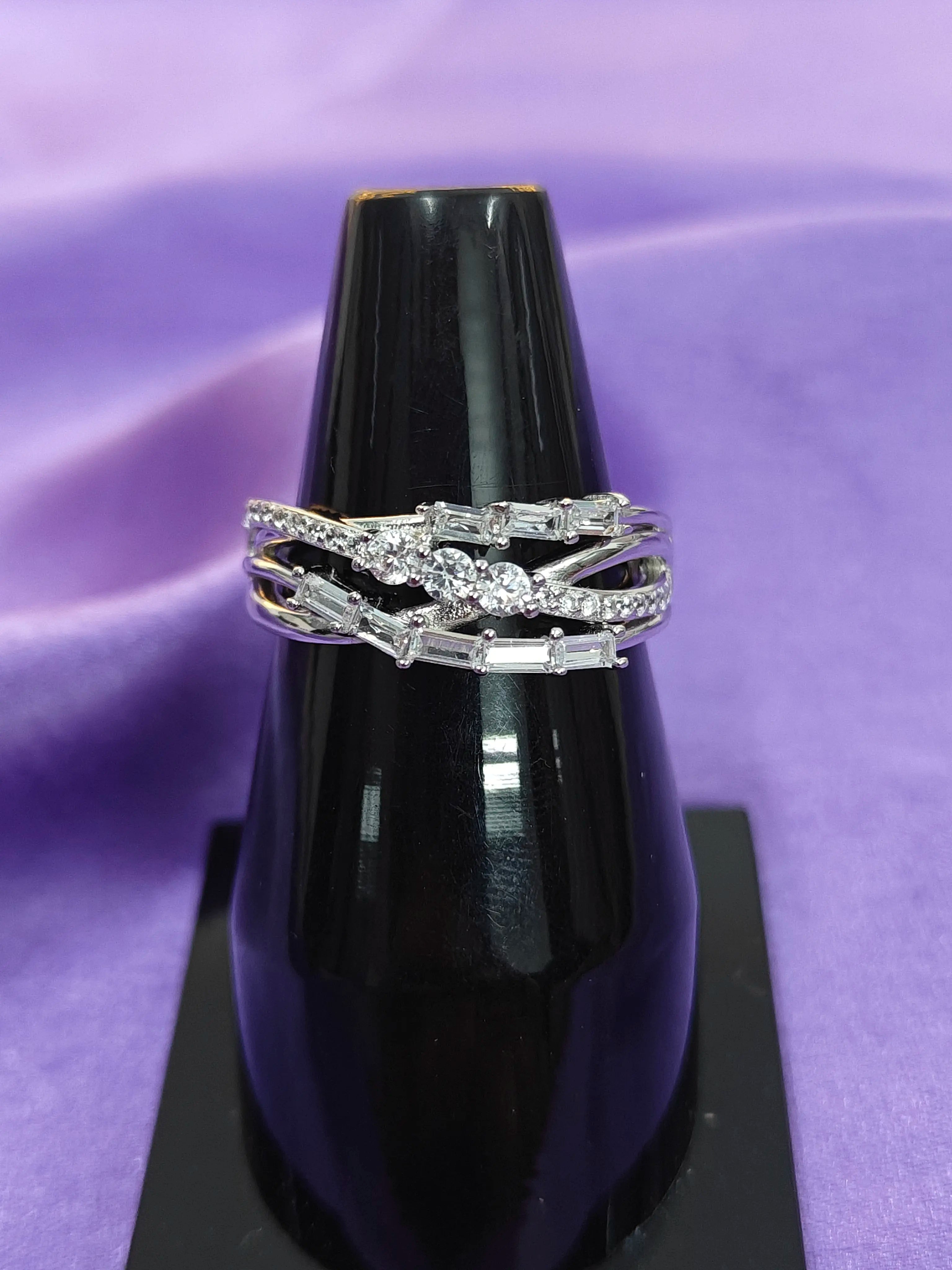 Diamond ring on a black stand with a purple background