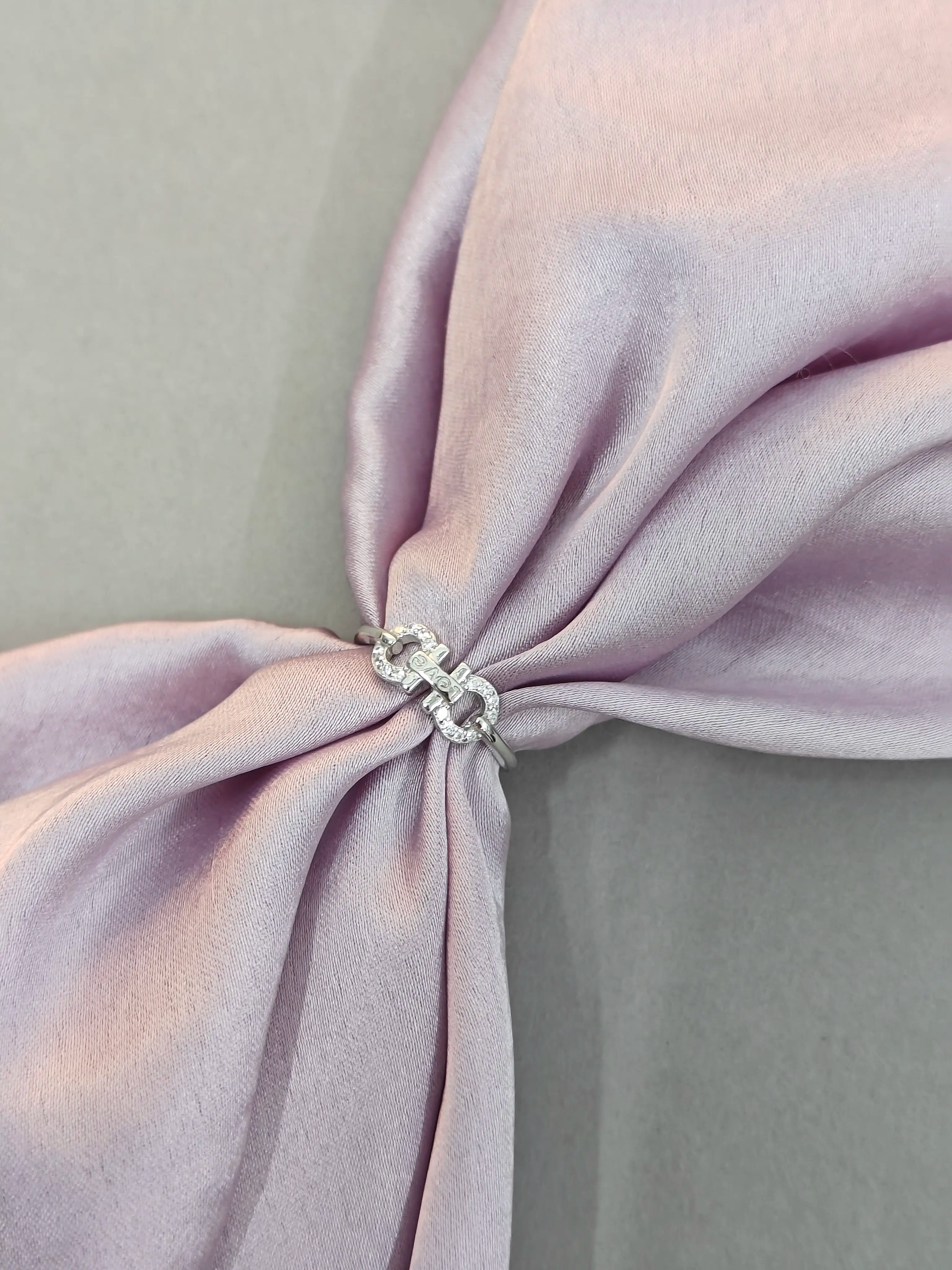 Close-up of a lavender fabric with a decorative ring on a light gray background