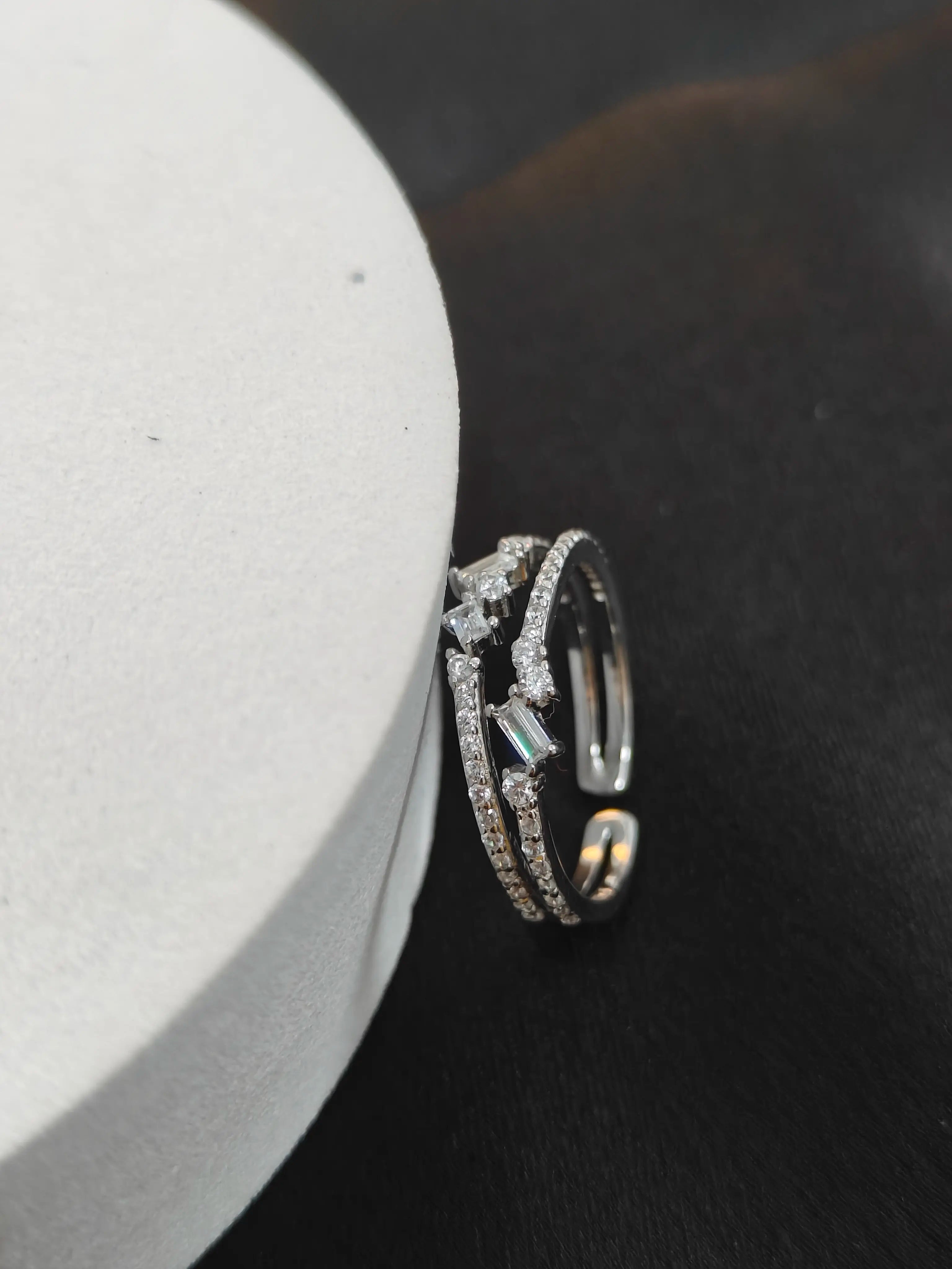 Silver ring with gemstones on a black surface