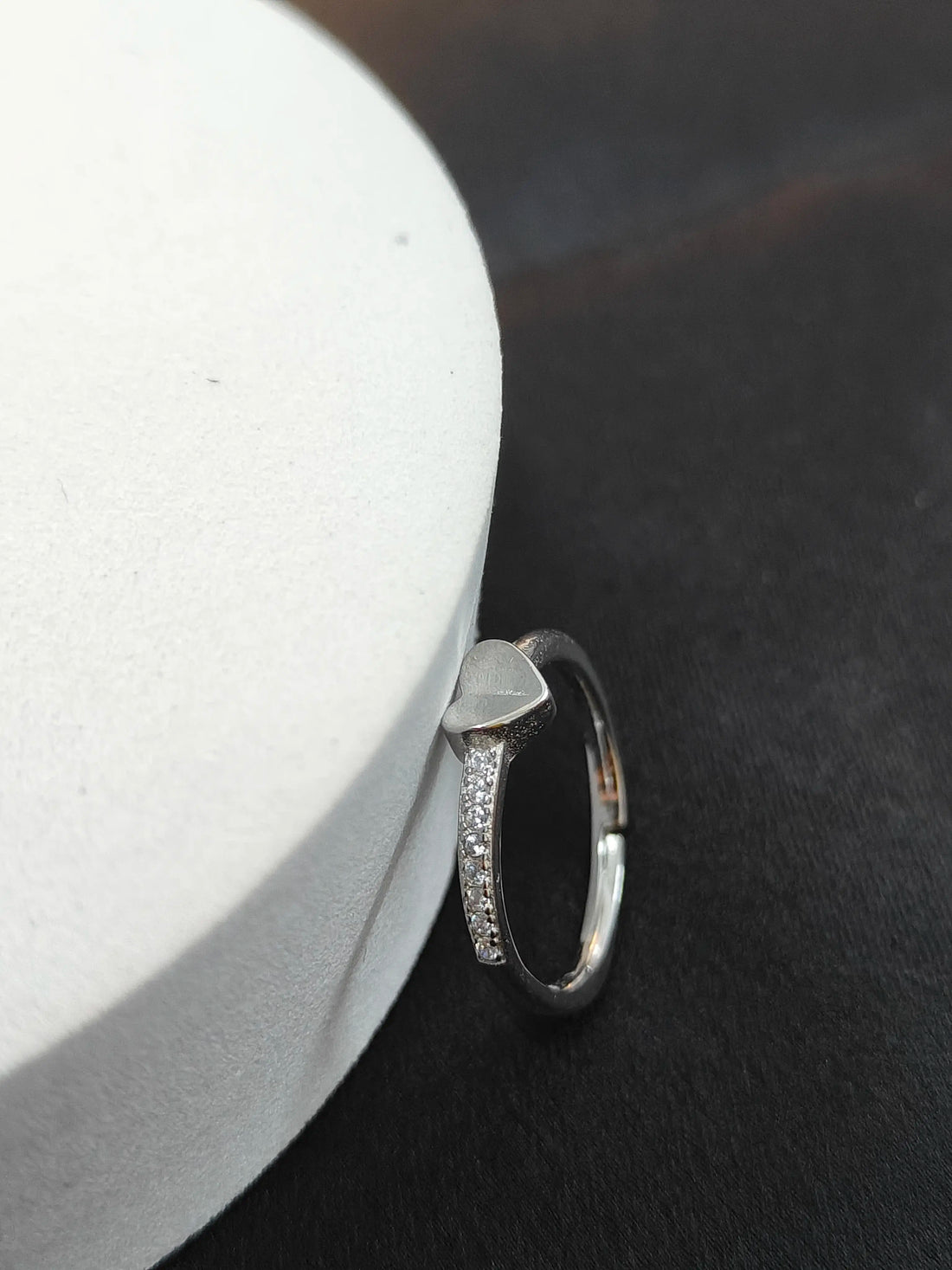 Silver ring with small diamonds on a black surface