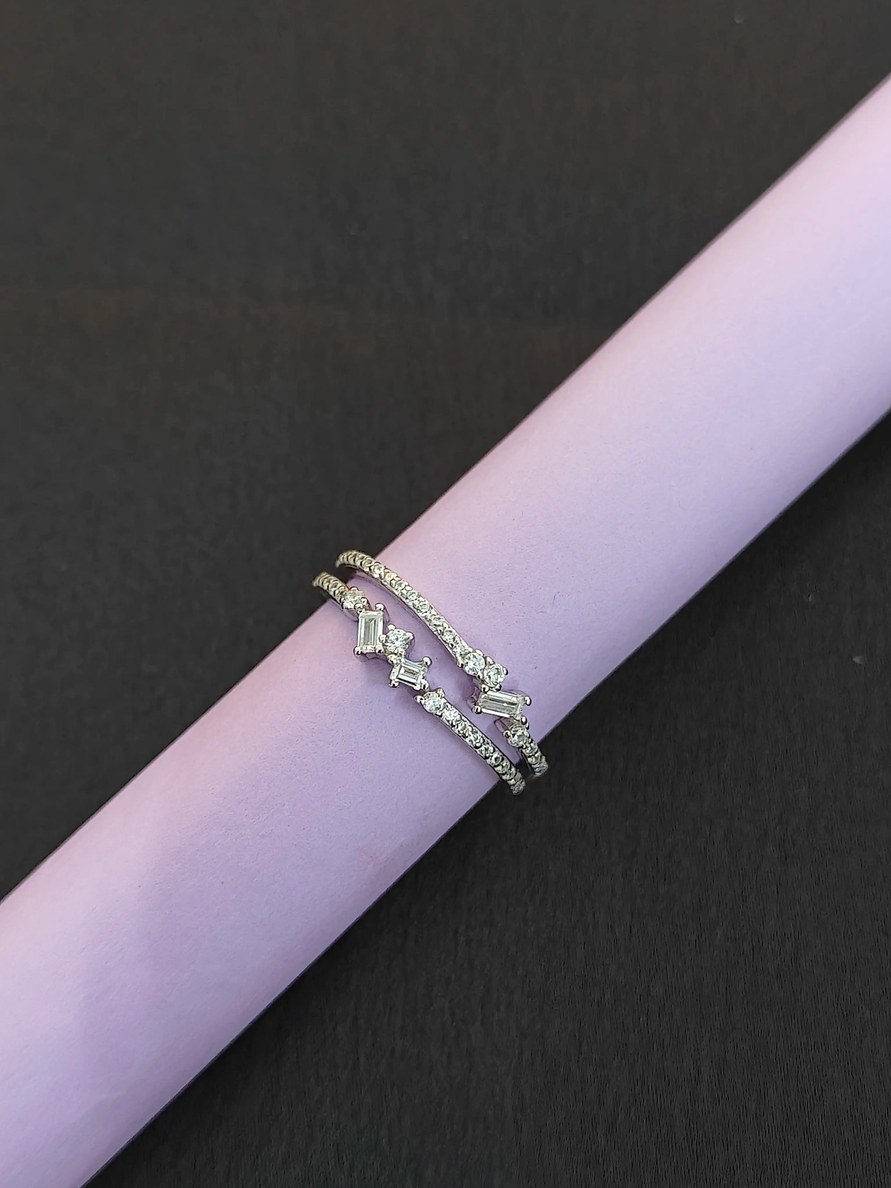 Silver bracelet with green gemstones on a black background