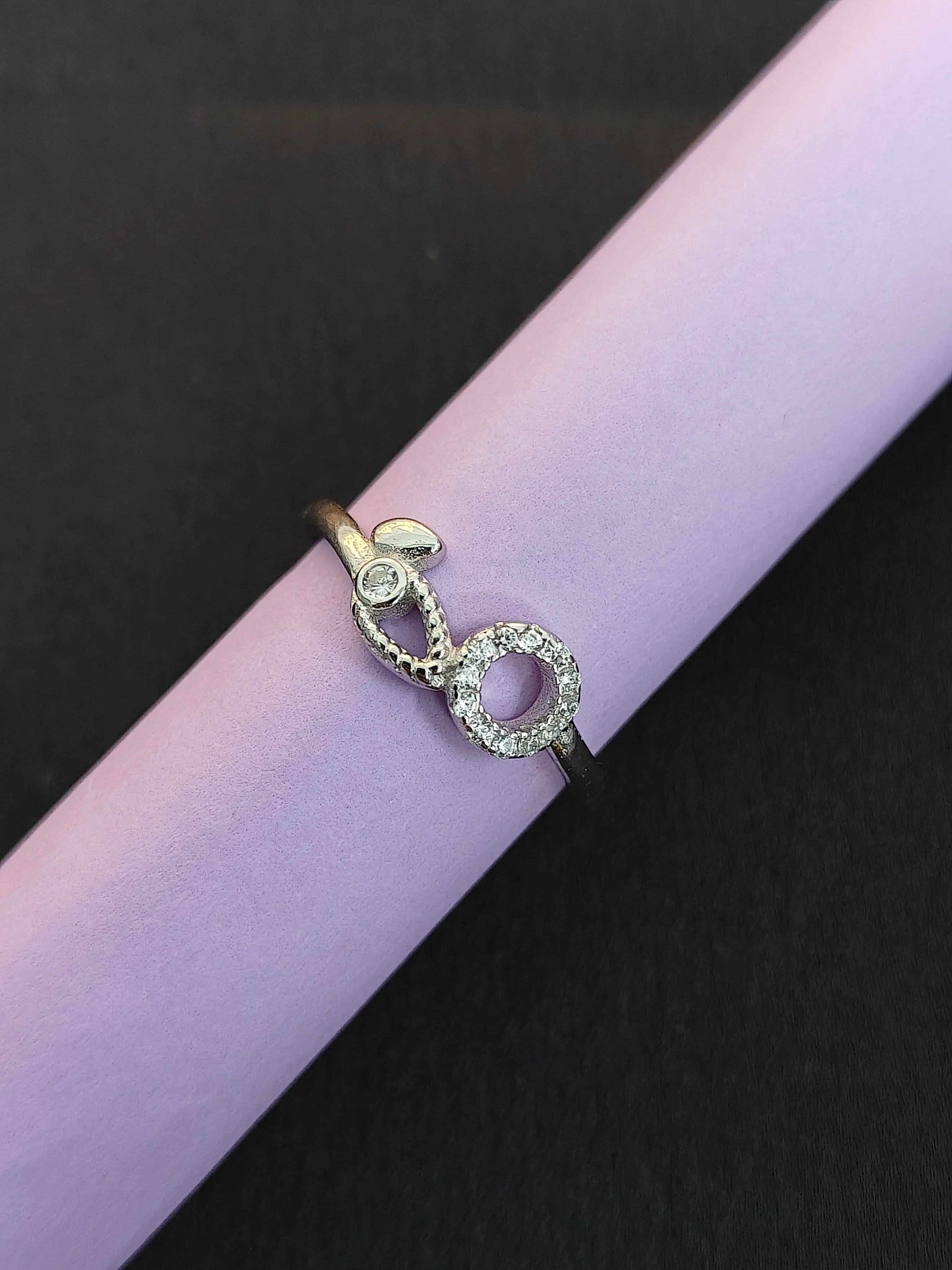 Gold and silver ring with gemstones on a purple surface