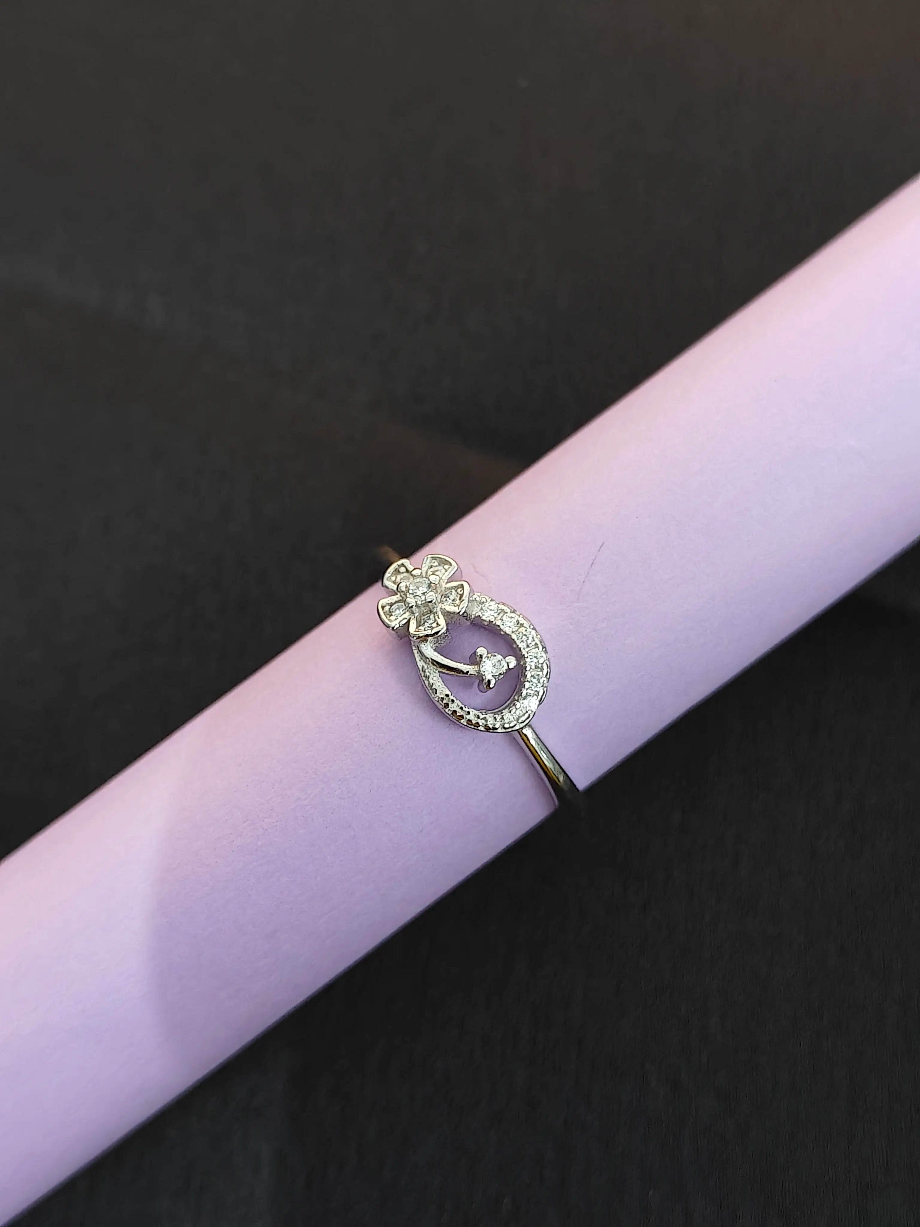 Silver brooch with purple gemstone on a black and purple background