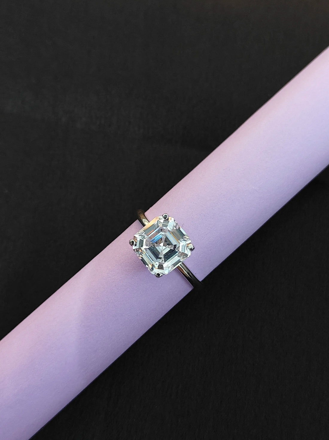 Diamond ring on a purple and black background