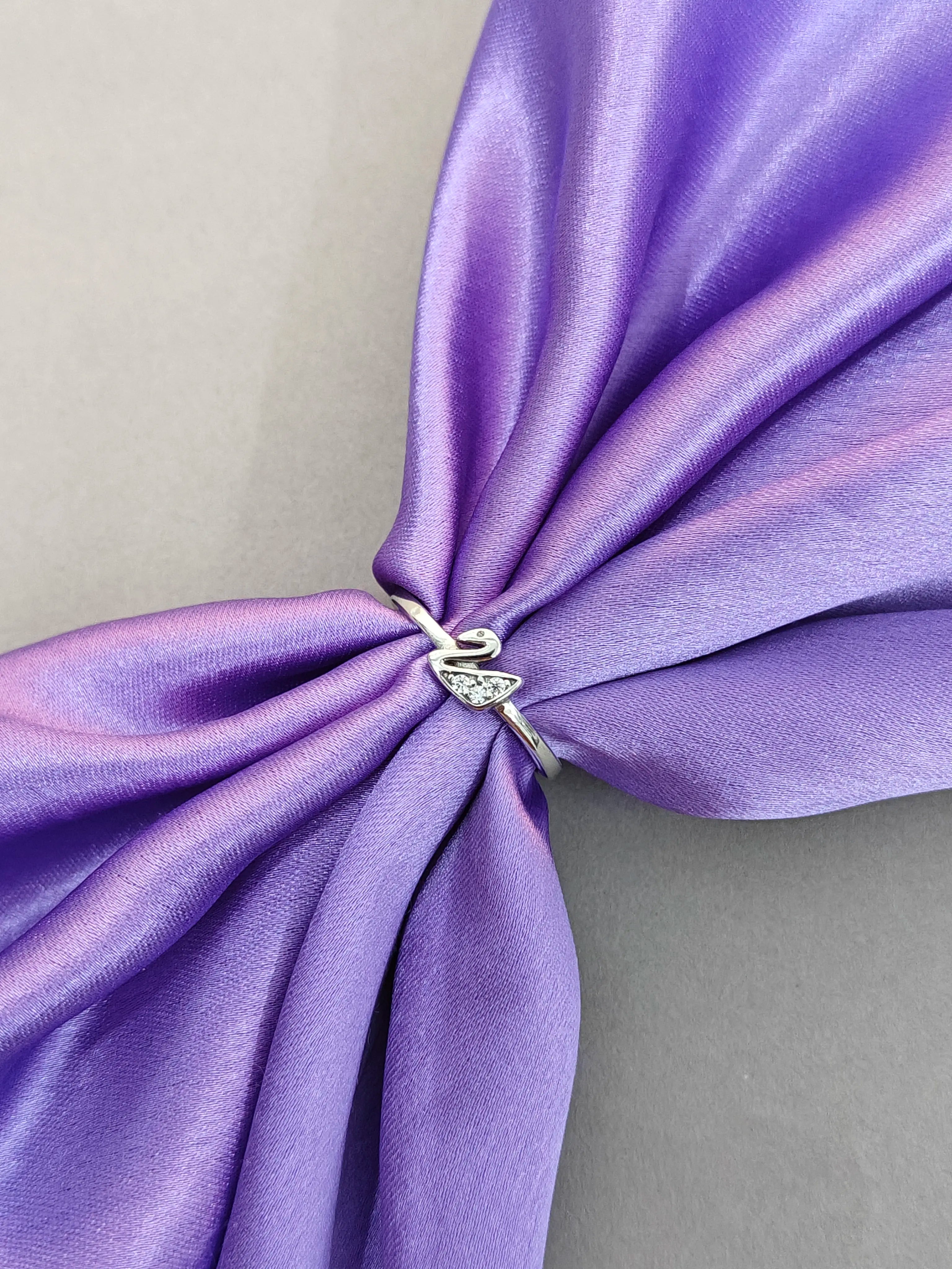 Purple fabric with a silver ring featuring a diamond on a gray background