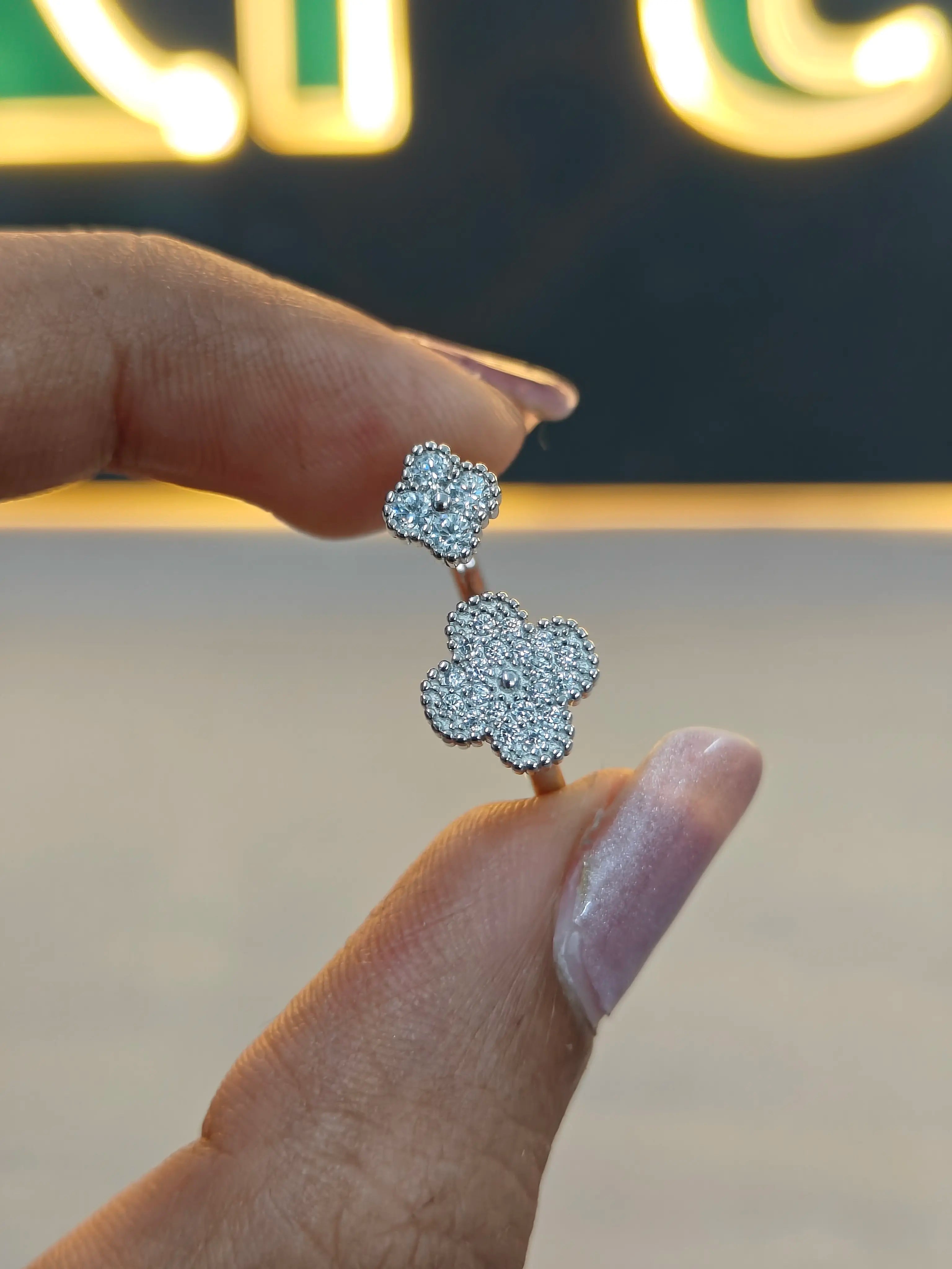 Diamond earrings held between fingers with a blurred background