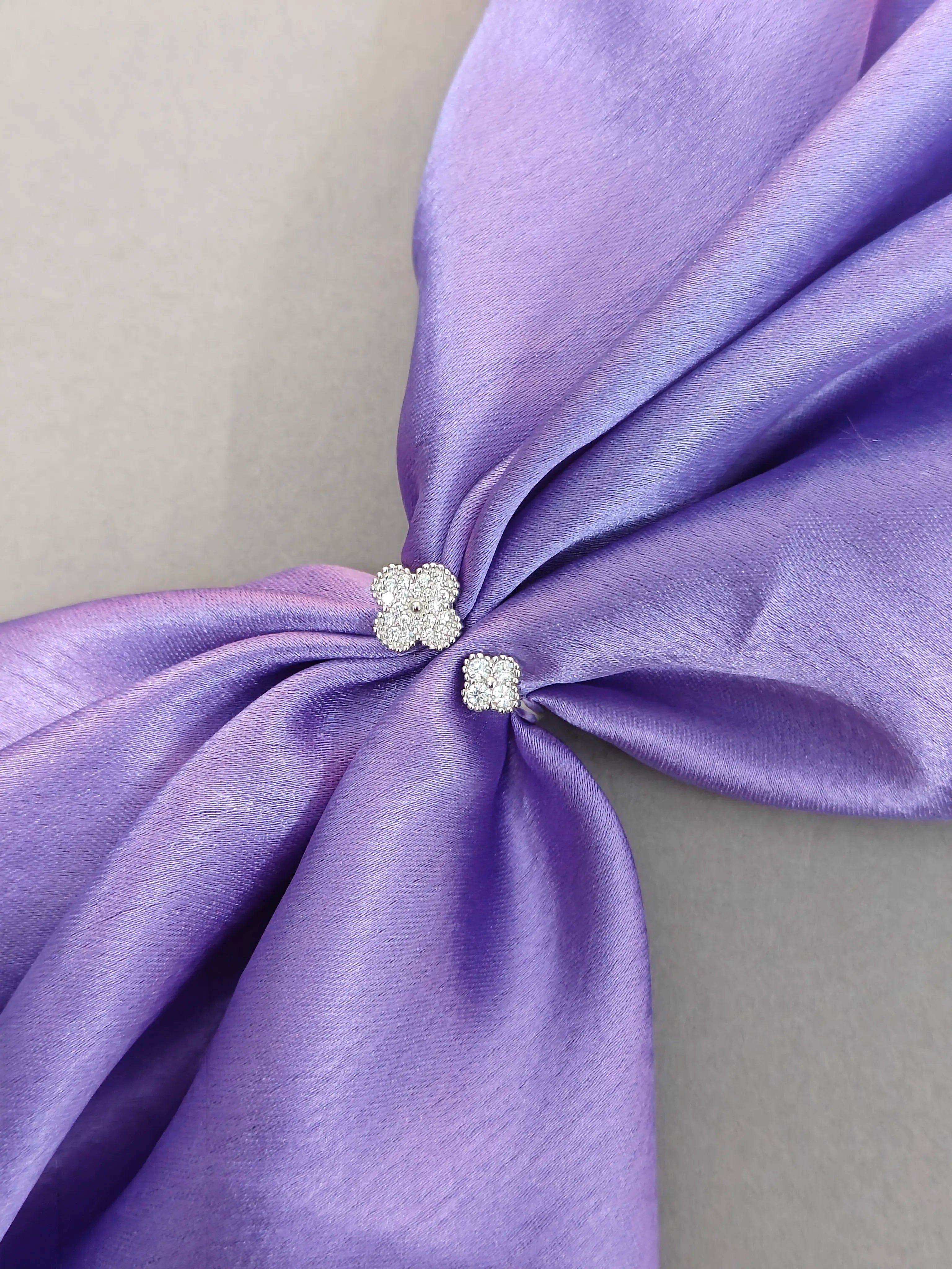 Close-up of a purple satin bow with decorative elements on a neutral background