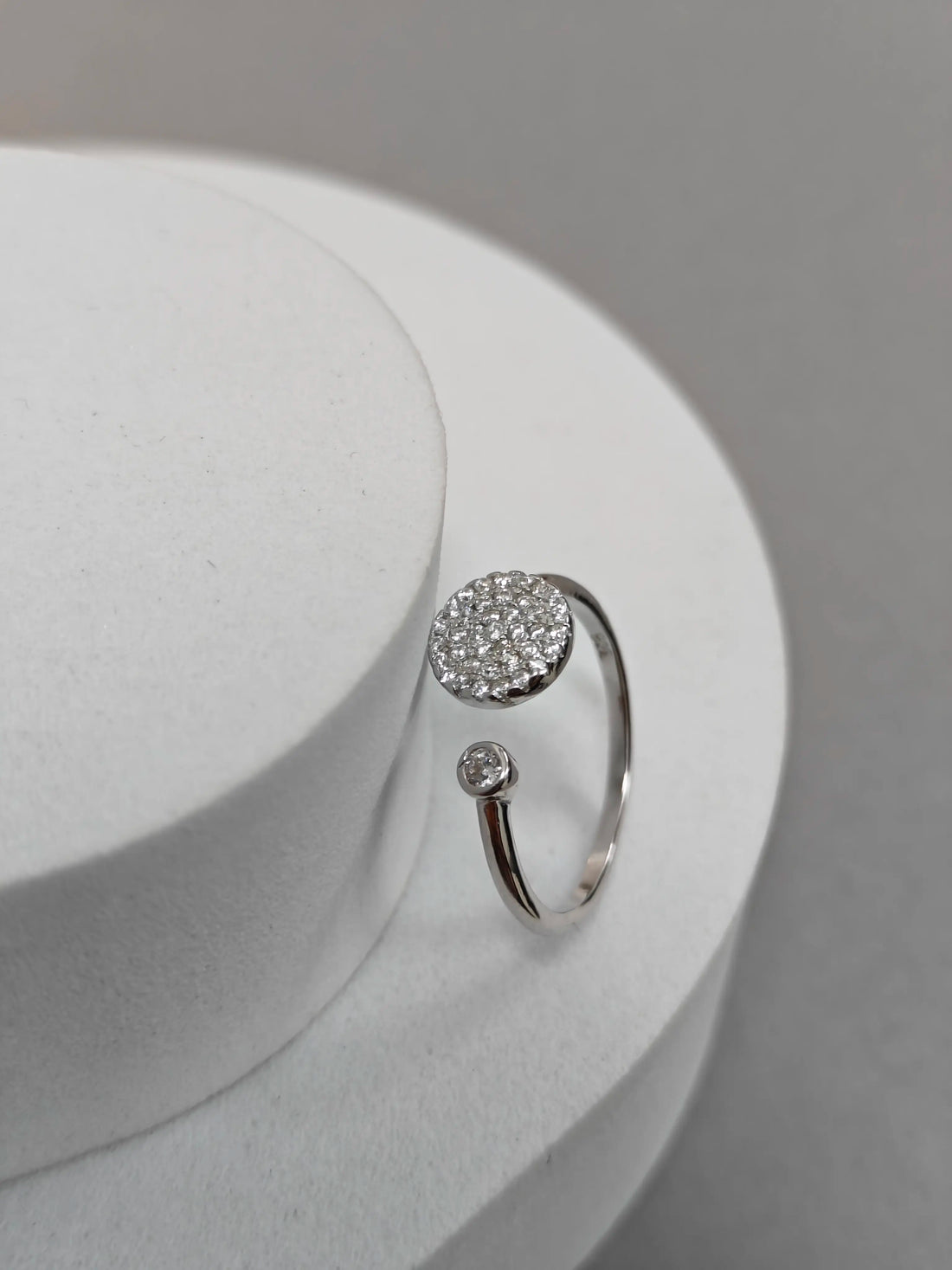 Silver ring with gemstones on a white surface