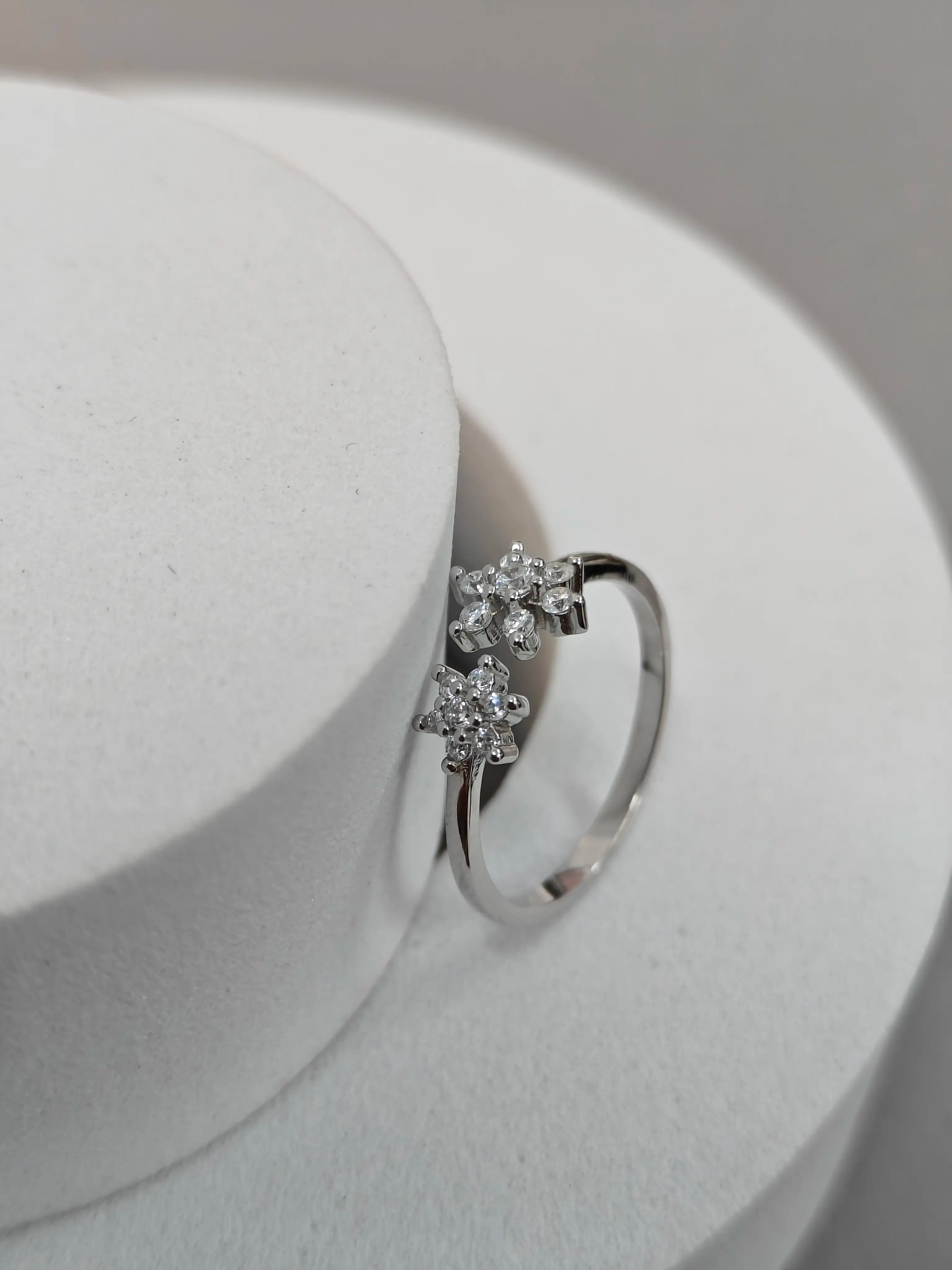 Silver ring with three diamond-like stones on a white background