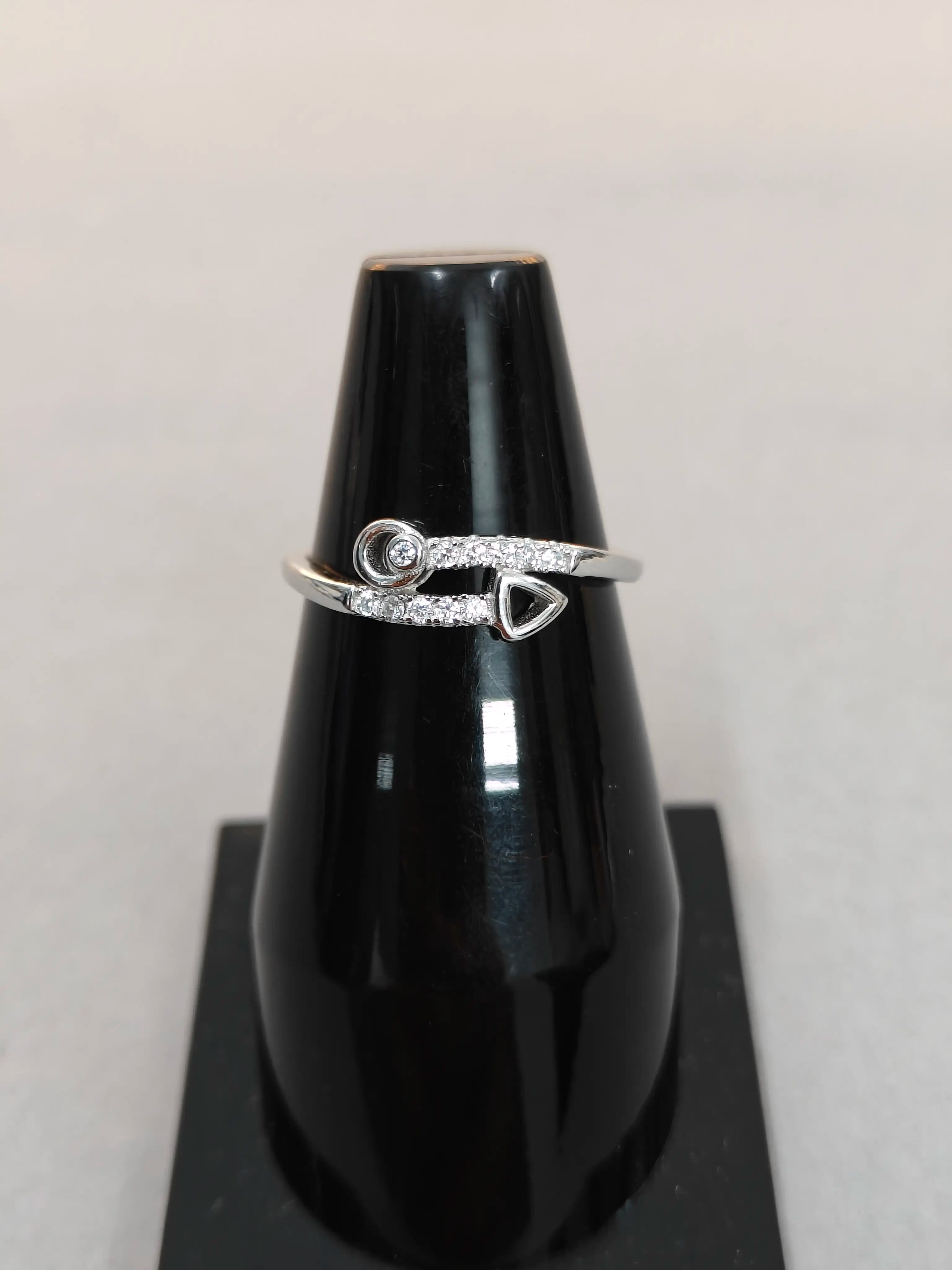 Silver ring with a black stand on a light gray background