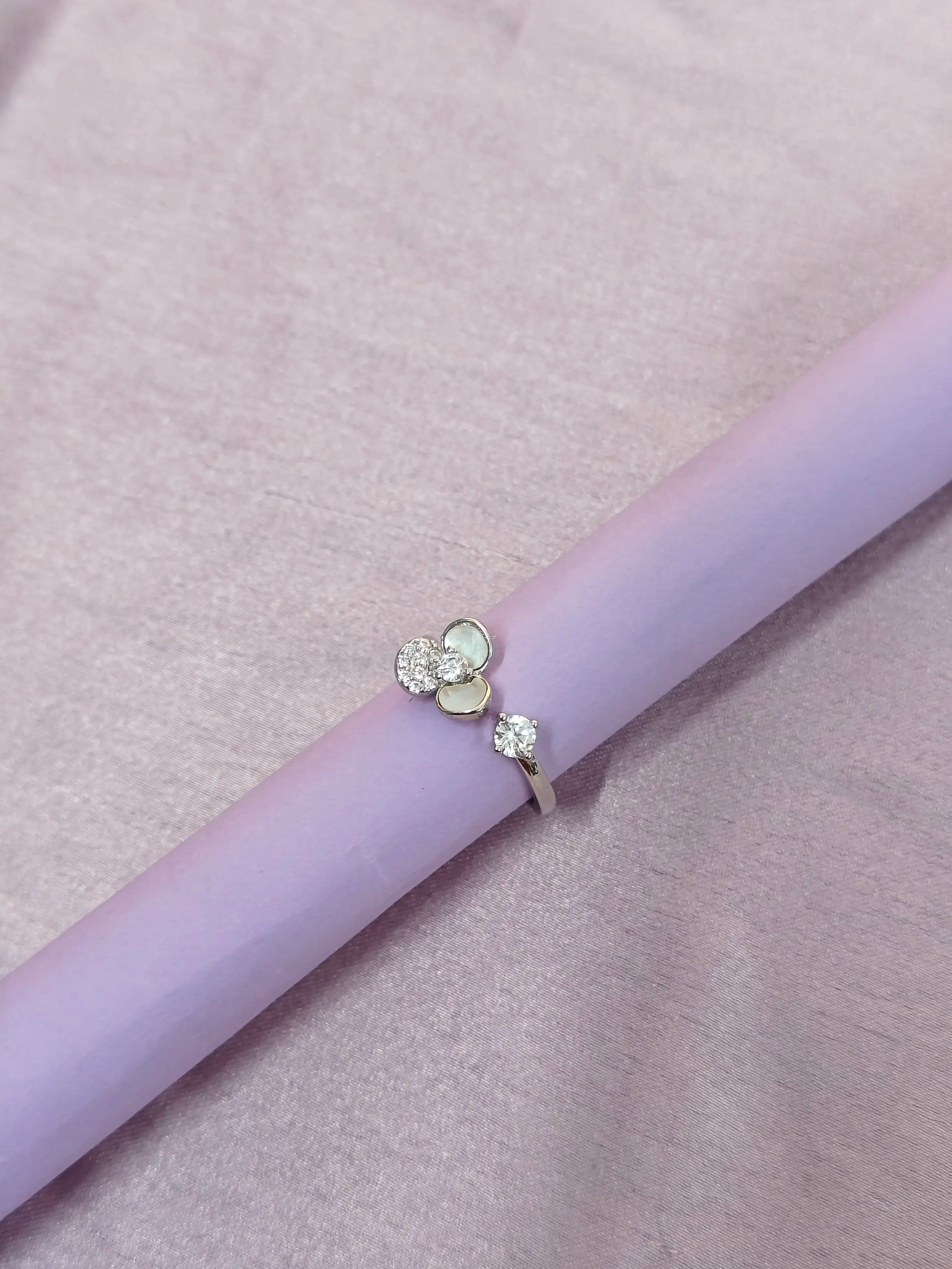 Ring with floral design on a light purple surface