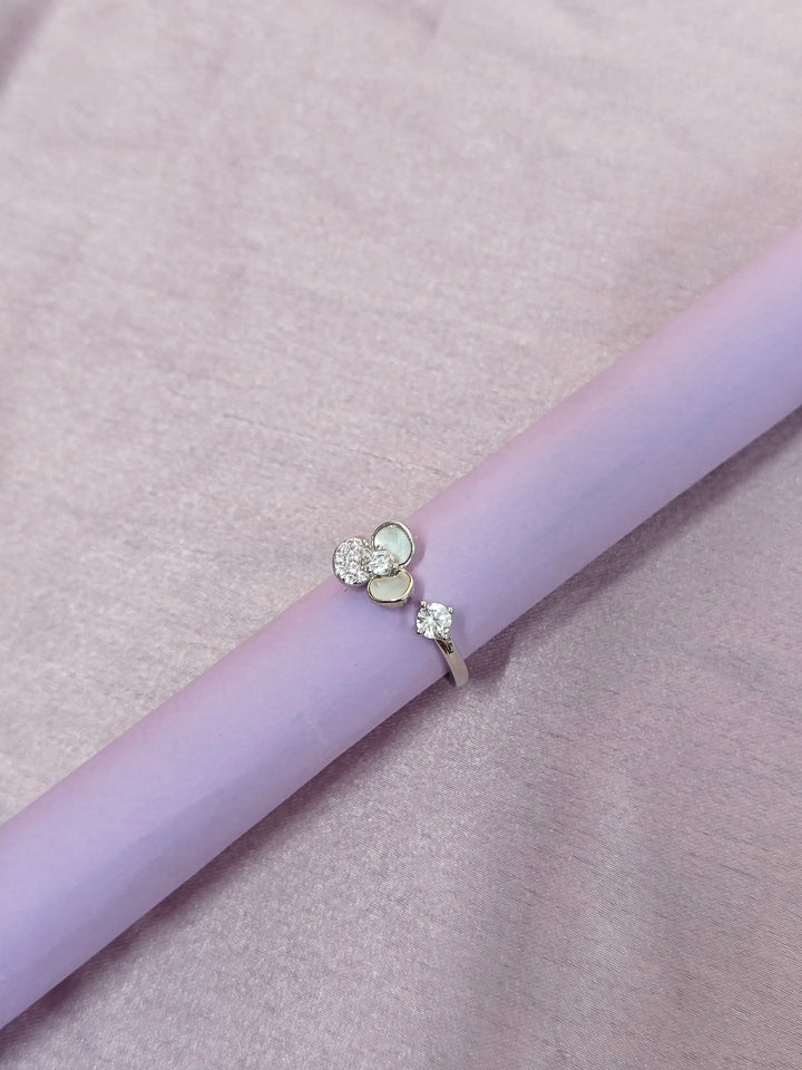 Ring with floral design on a light purple surface