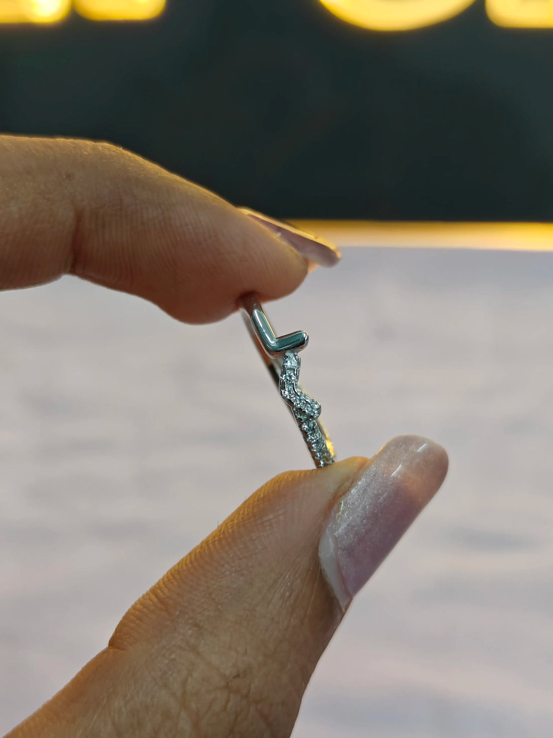 Hand holding a silver earring with a blurred background