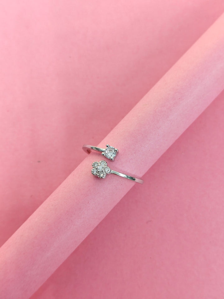Silver ring with gemstones on a pink background