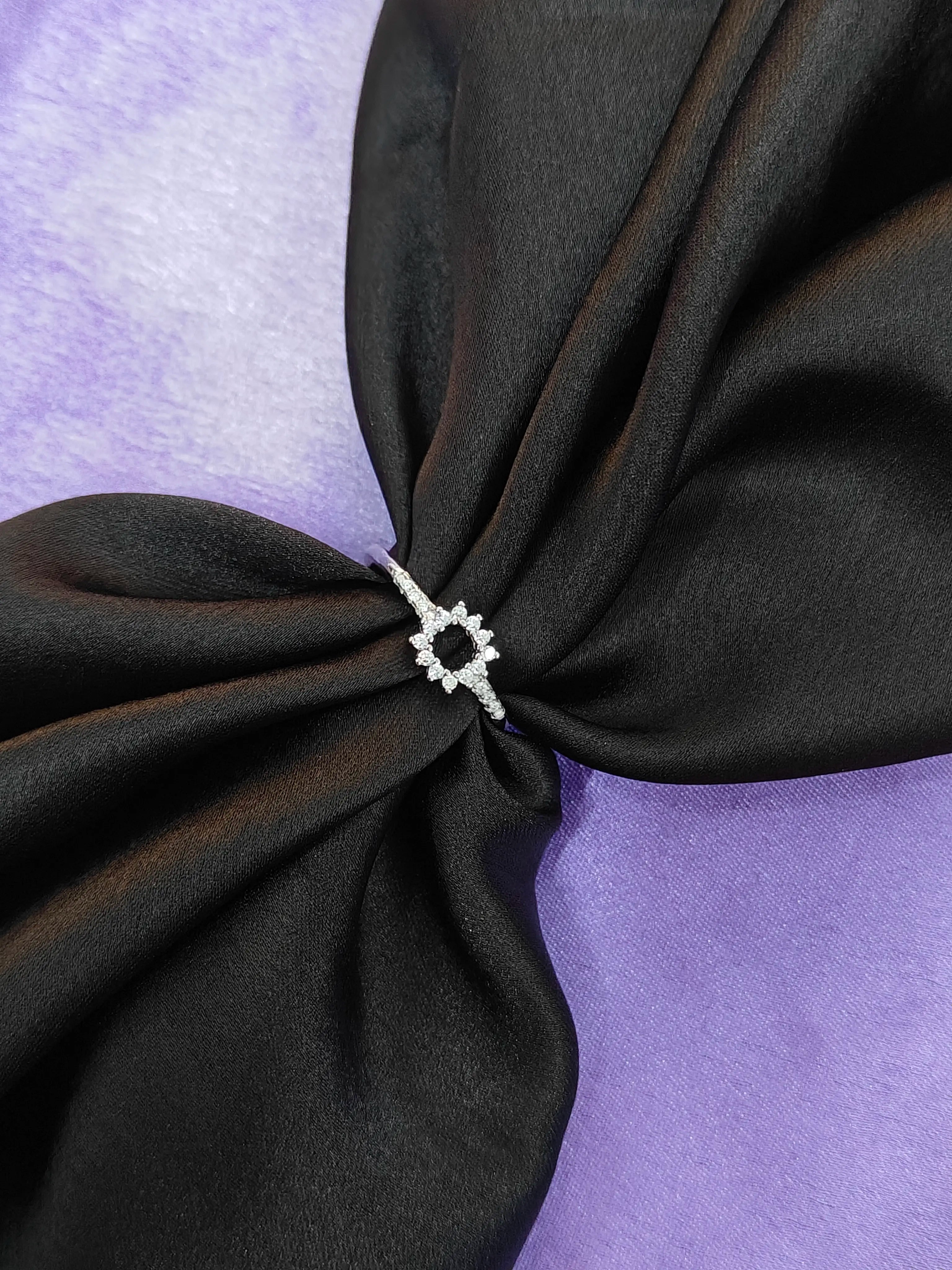 Black fabric with a decorative white knot on a purple background