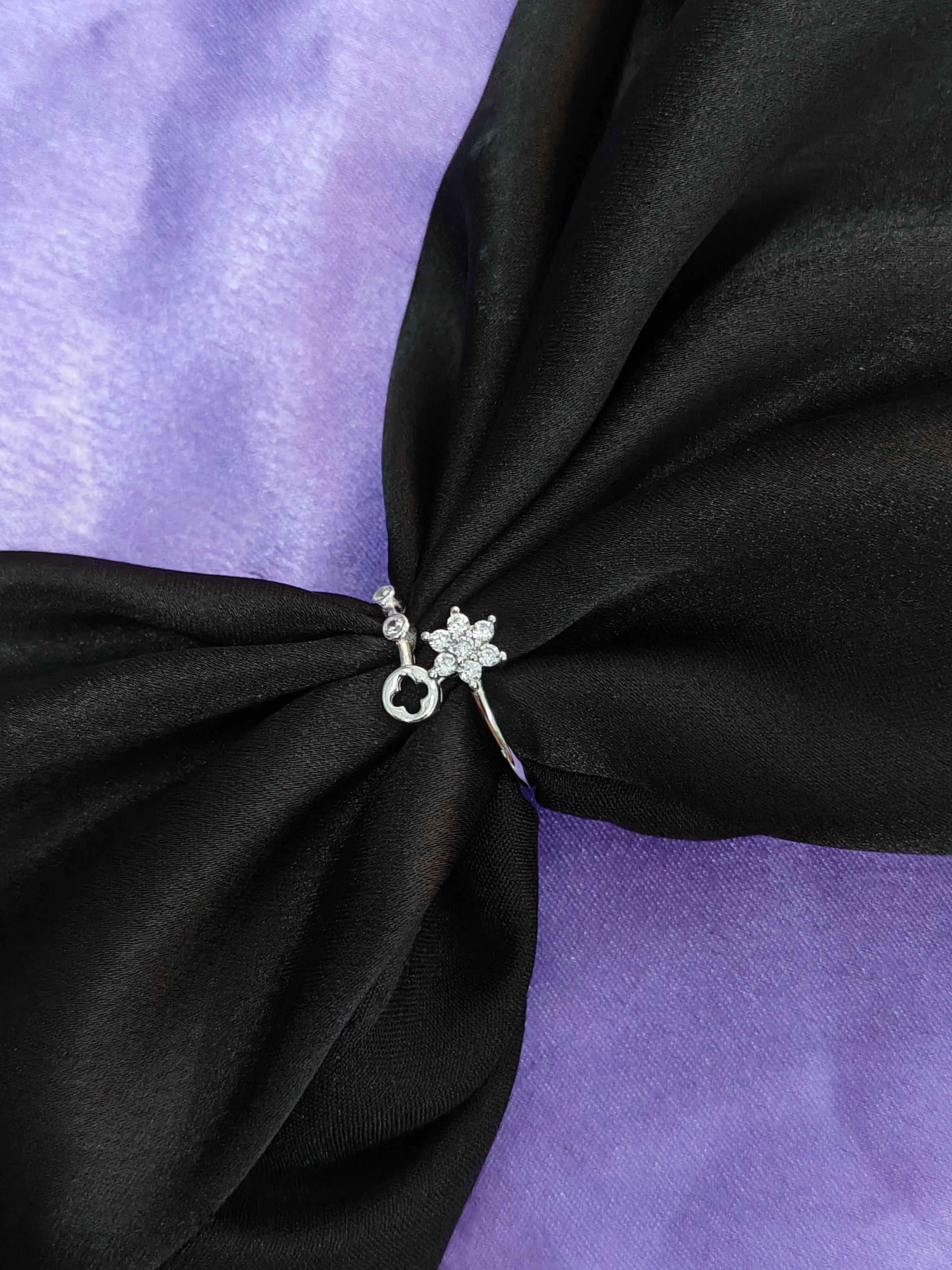 Black fabric with a decorative brooch on a purple background