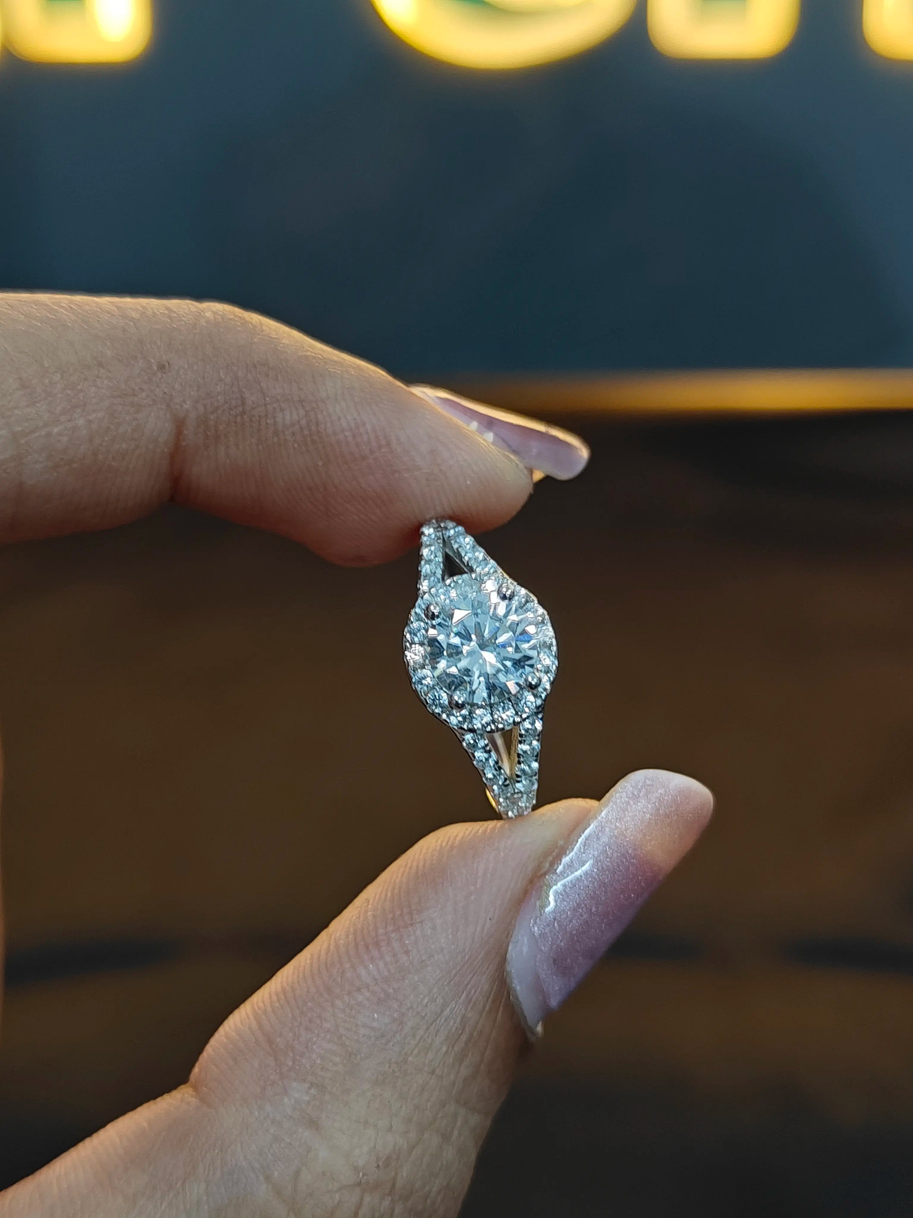 Diamond earring held between fingers against a blurred background