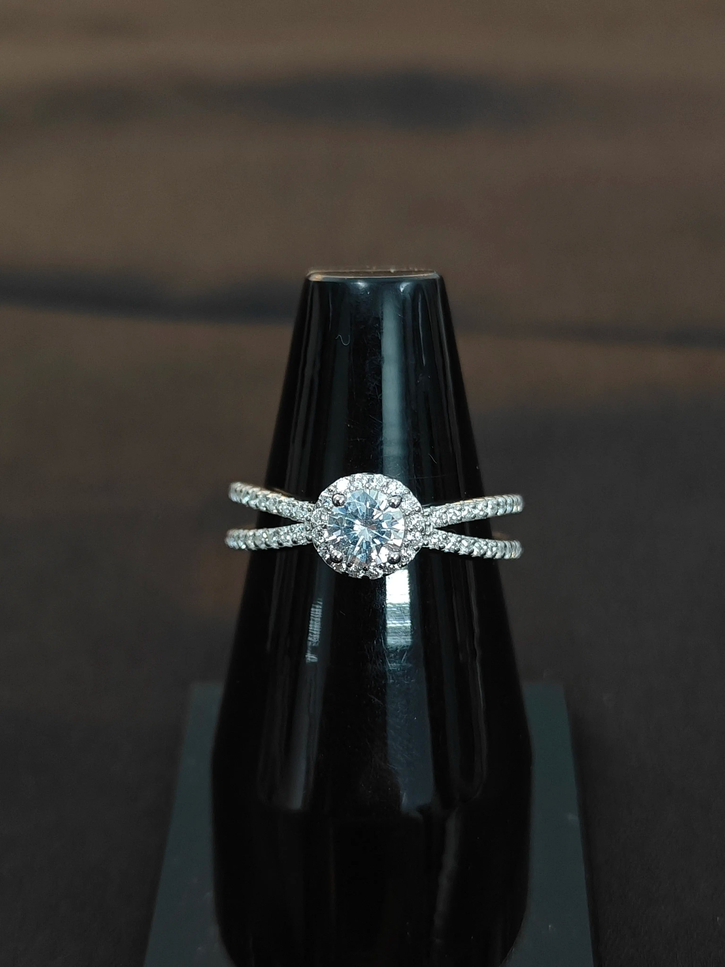 Diamond ring on a black stand against a dark background